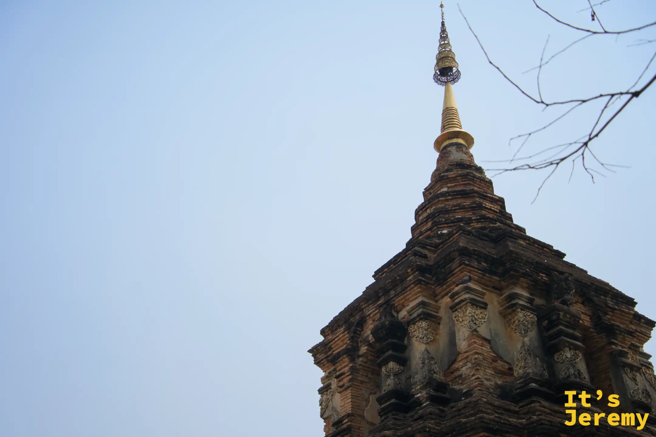 古磚砌佛塔仰拍，多層磚砌塔身風化明顯，頂部金色相輪尖頂依然完整