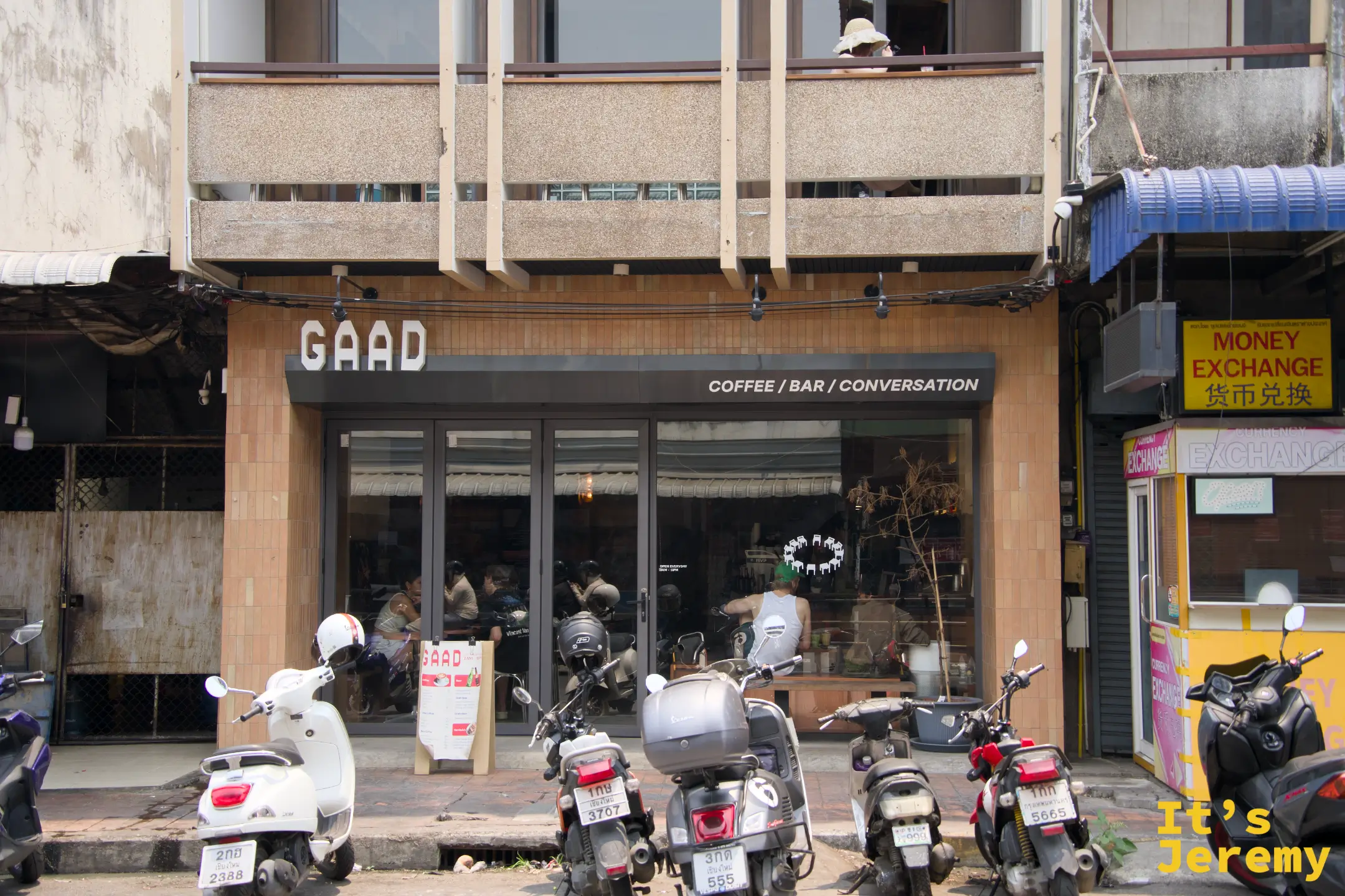 GAAD 店面全貌，機車停滿門口，玻璃門內可見坐滿的客人