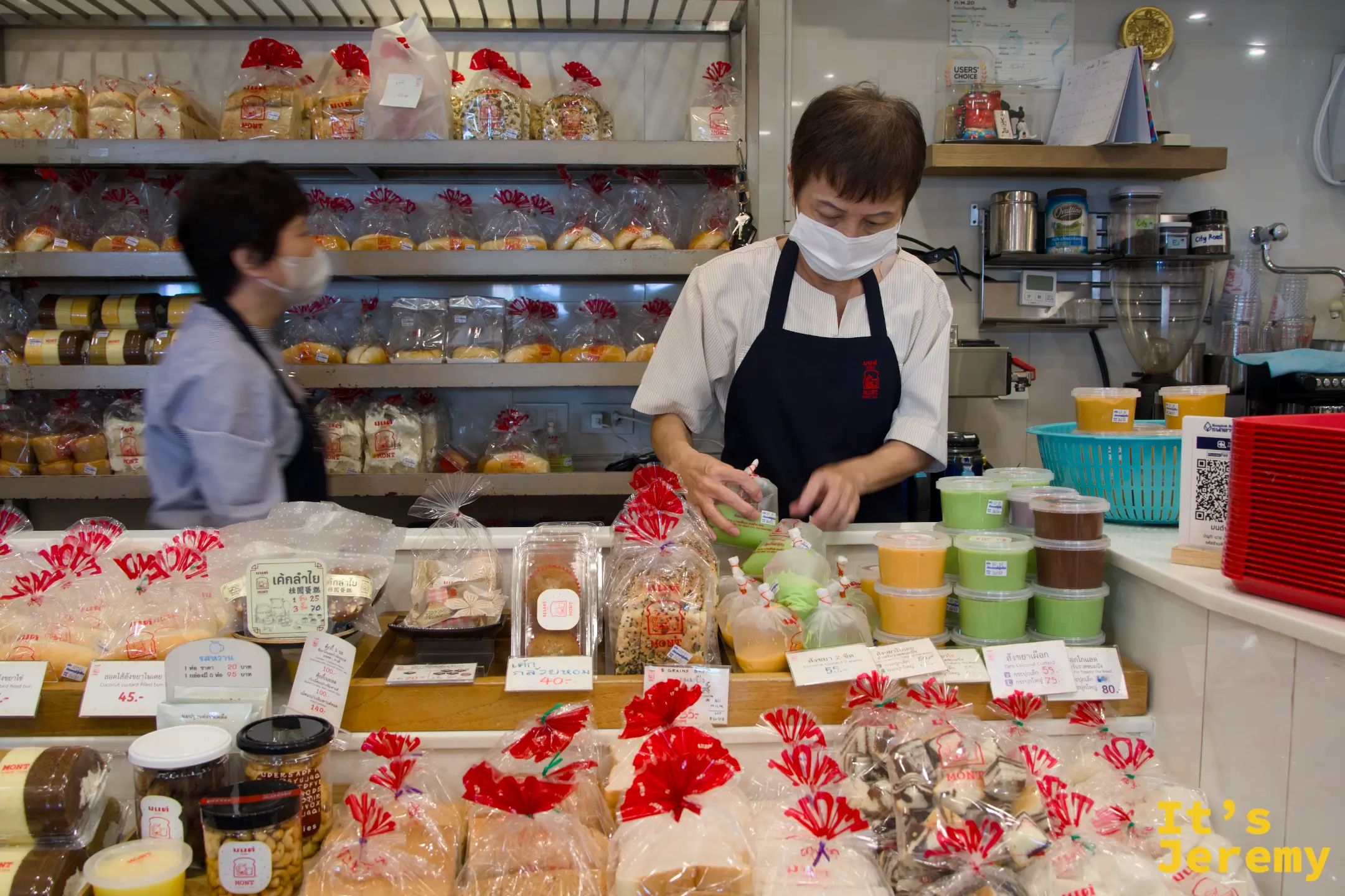 店員正在櫃檯內忙著製作吐司，背景是熱壓吐司機