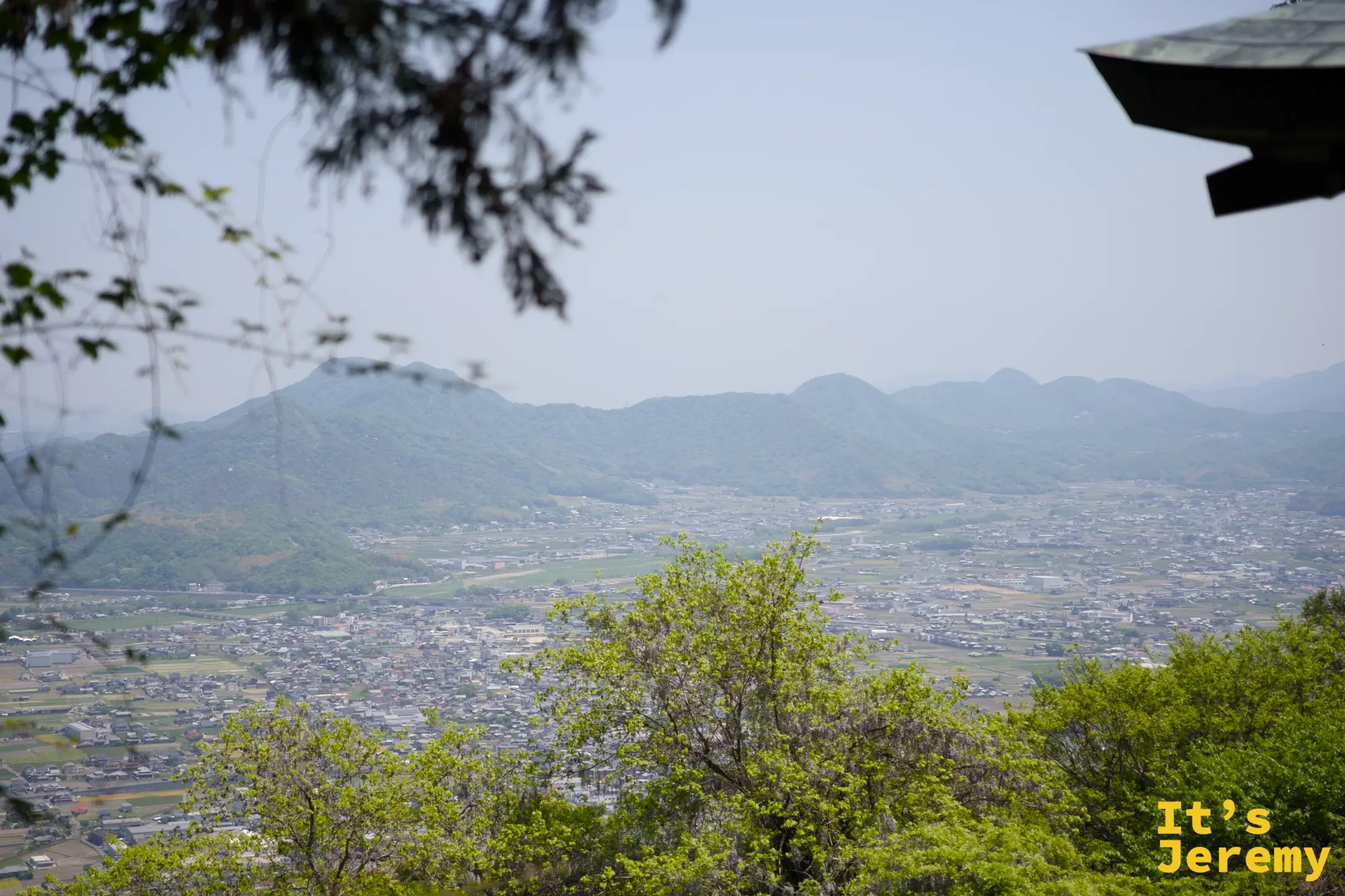 從奧社附近的制高點望見讚岐平野，右上角隱約露出神社屋簷一角