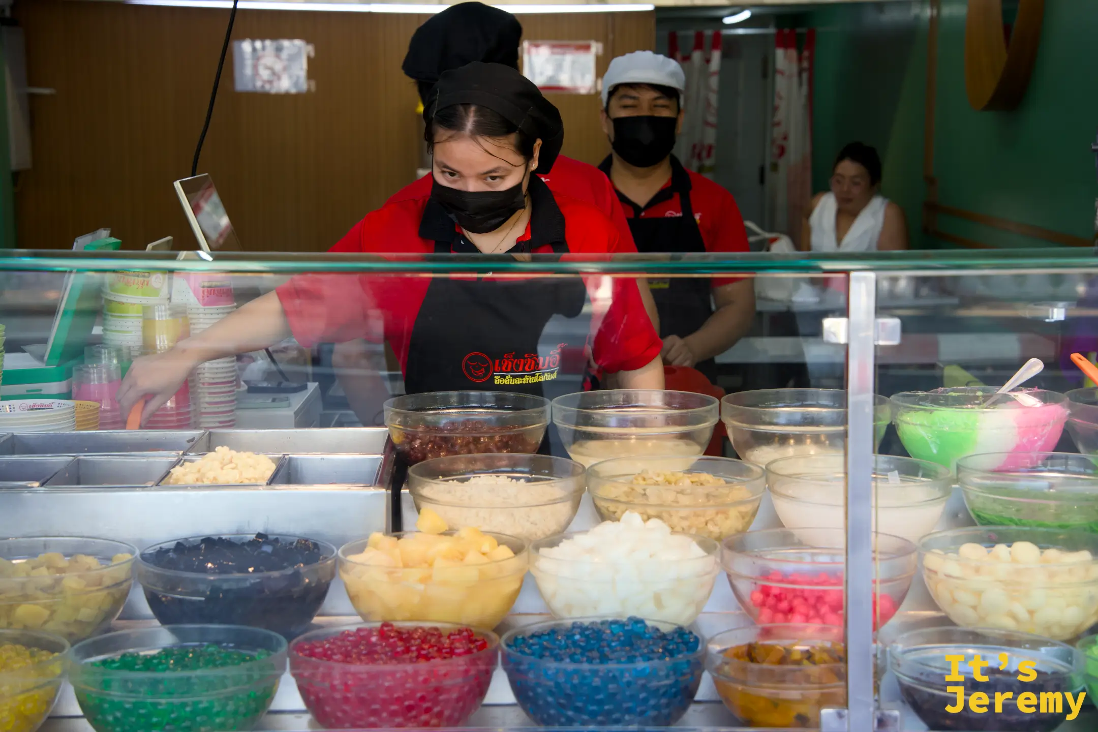 店員在配料盆後方準備食材的瞬間