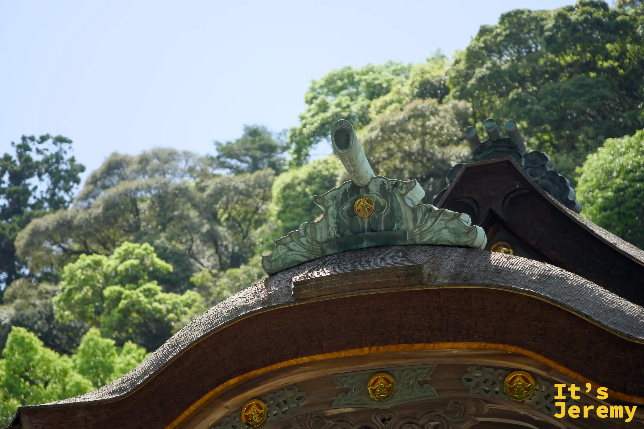 三穂津姫神社屋頂頂端特寫，青銅色的鶴形裝飾加上金色金丸印徽章，點綴在唐破風曲線上