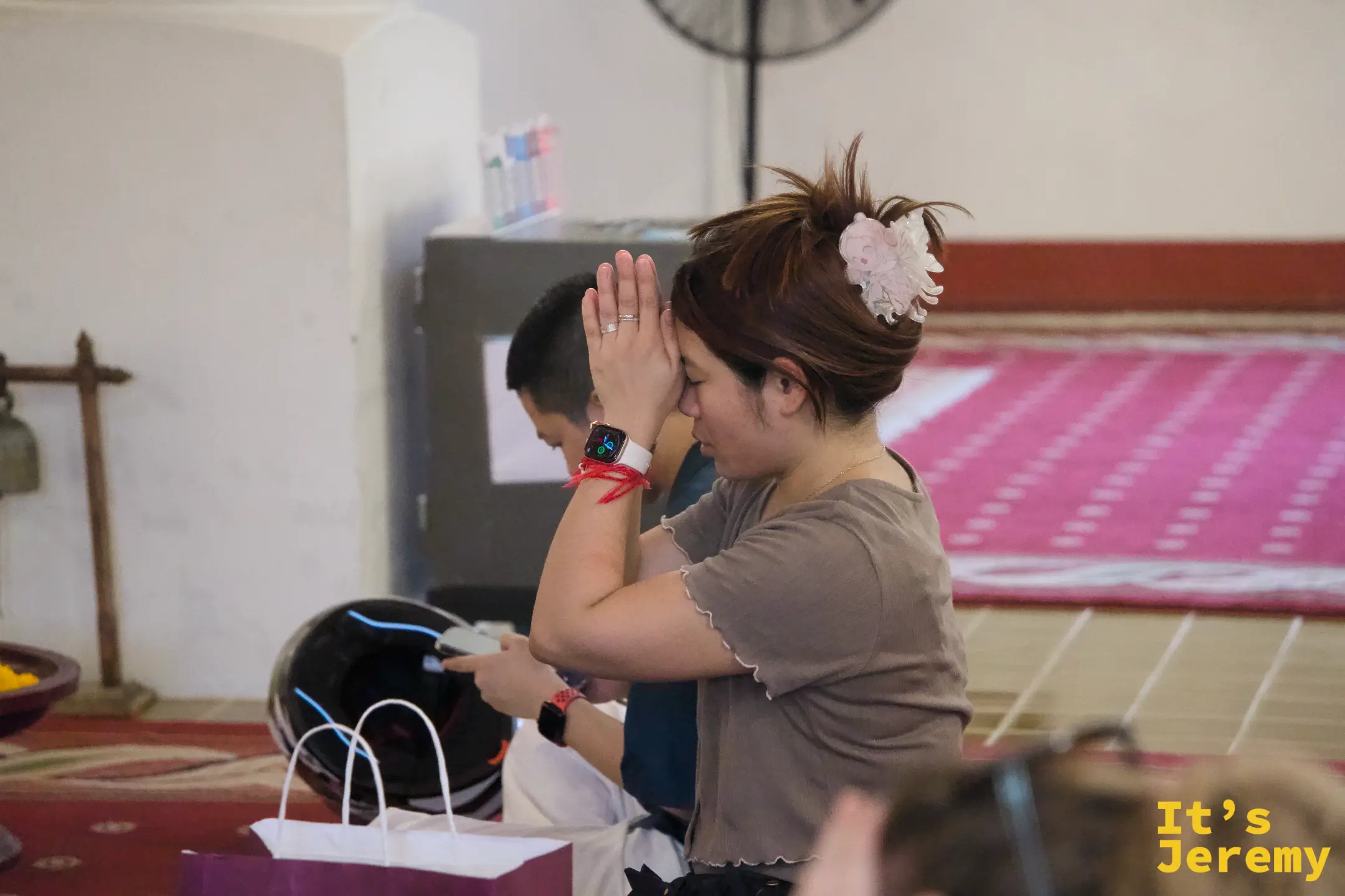 女信徒雙手合十，閉眼祈福，神情虔誠