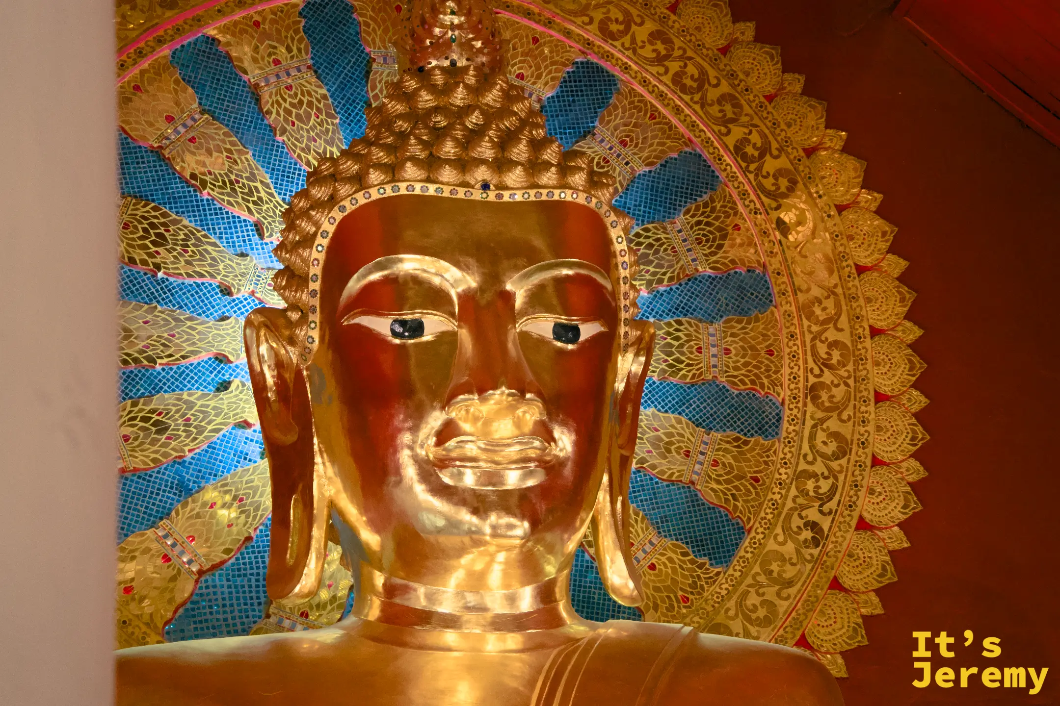 主殿大佛臉部特寫，金色佛面，藍色馬賽克圓形背光，神情沉靜