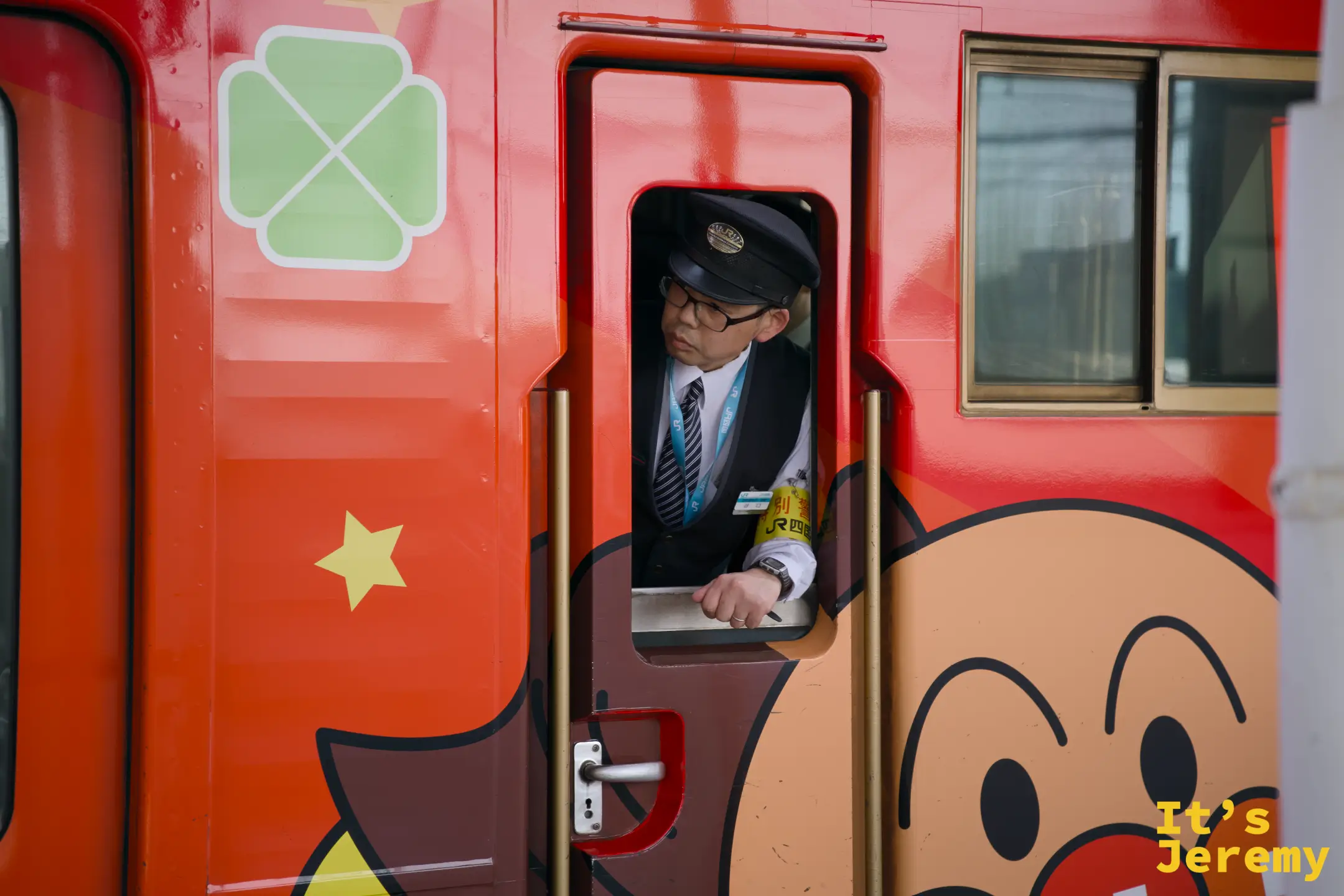 麵包超人彩繪特急列車車廂，橙紅色車身繪有麵包超人圖案，司機從車窗探頭張望