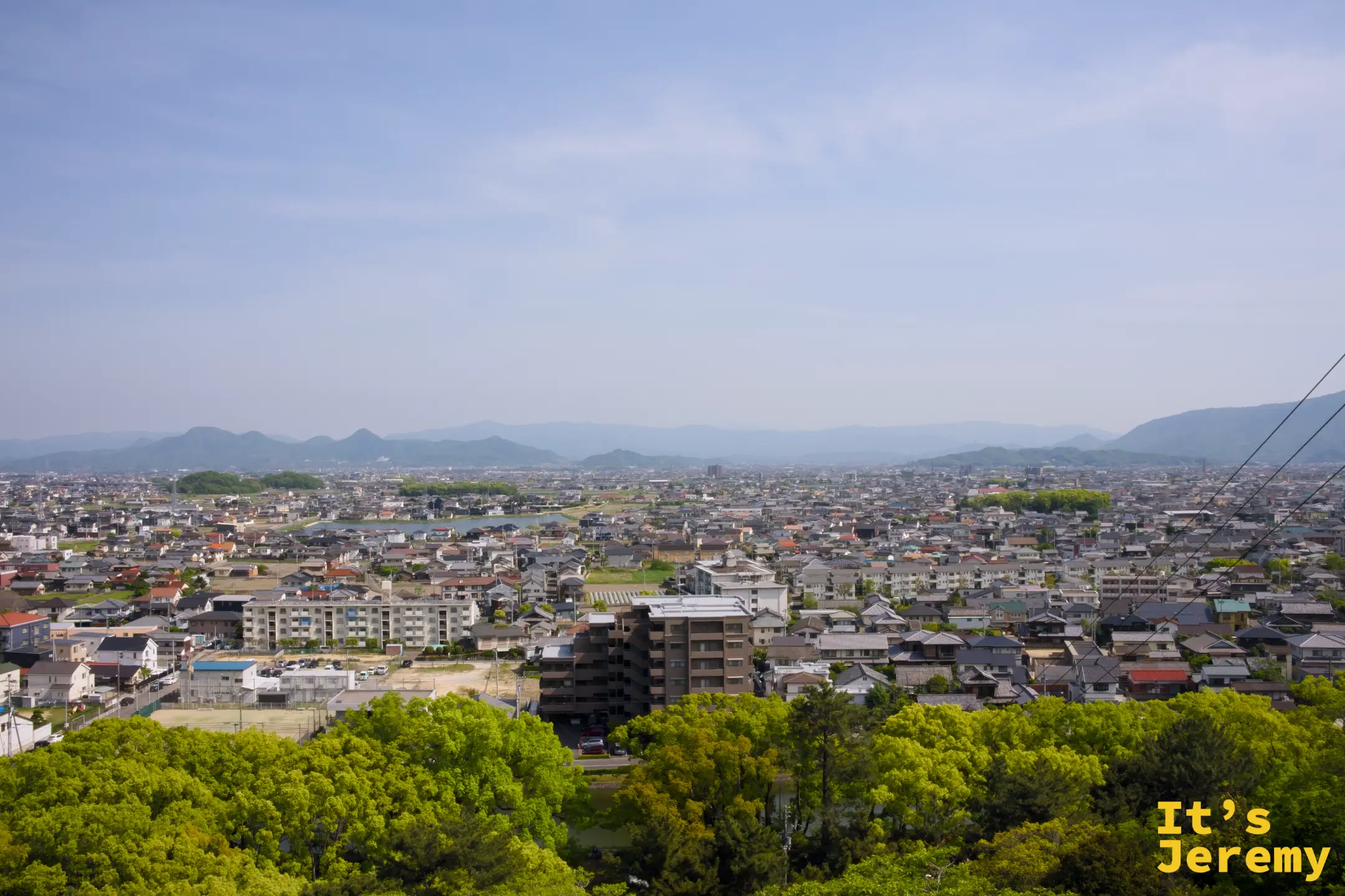 從天守俯瞰丸亀市街，遠方山脈連綿，晴天能見度極佳
