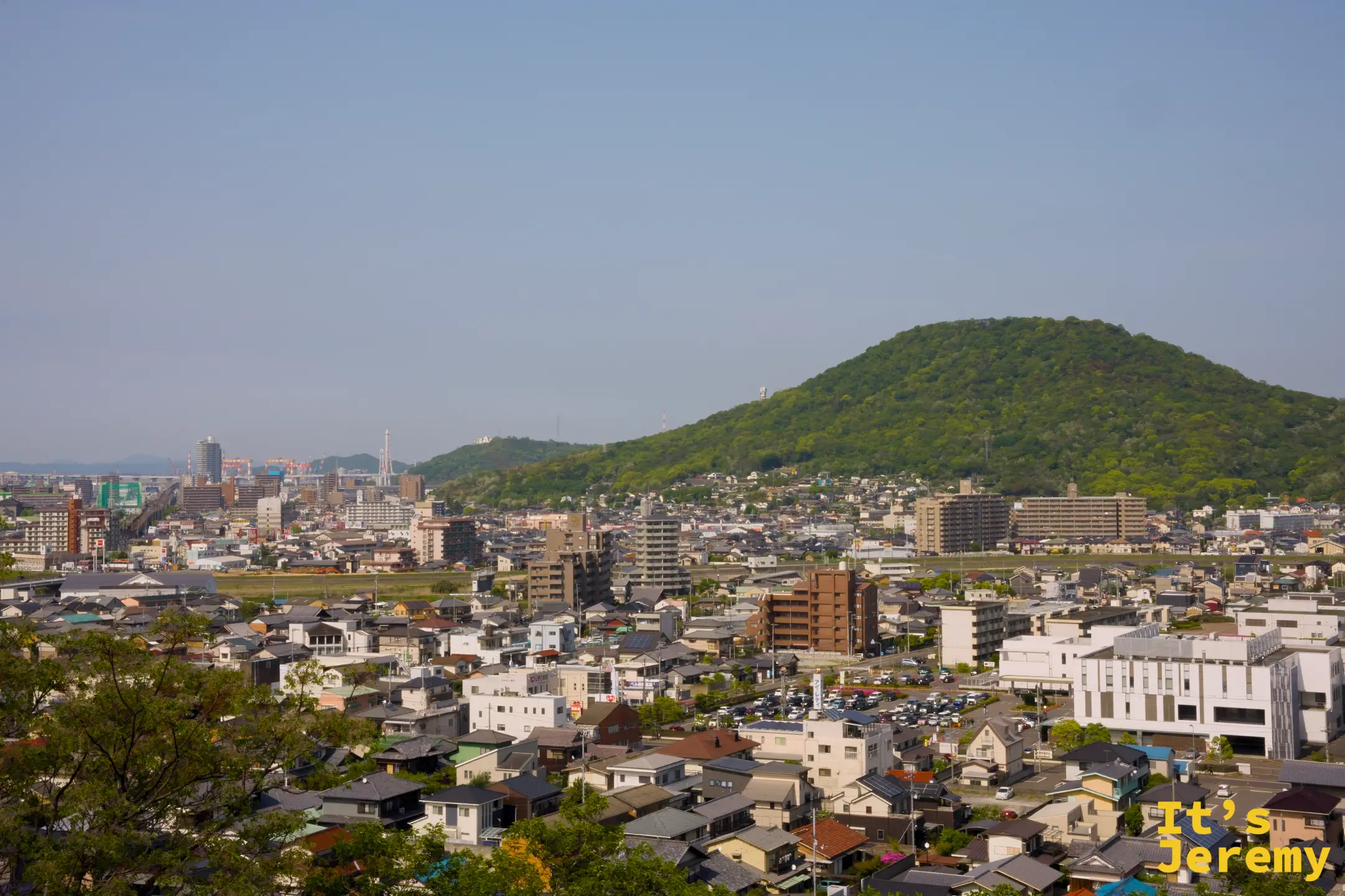 俯瞰丸亀市街另一角度，城市延伸至遠方海灣方向