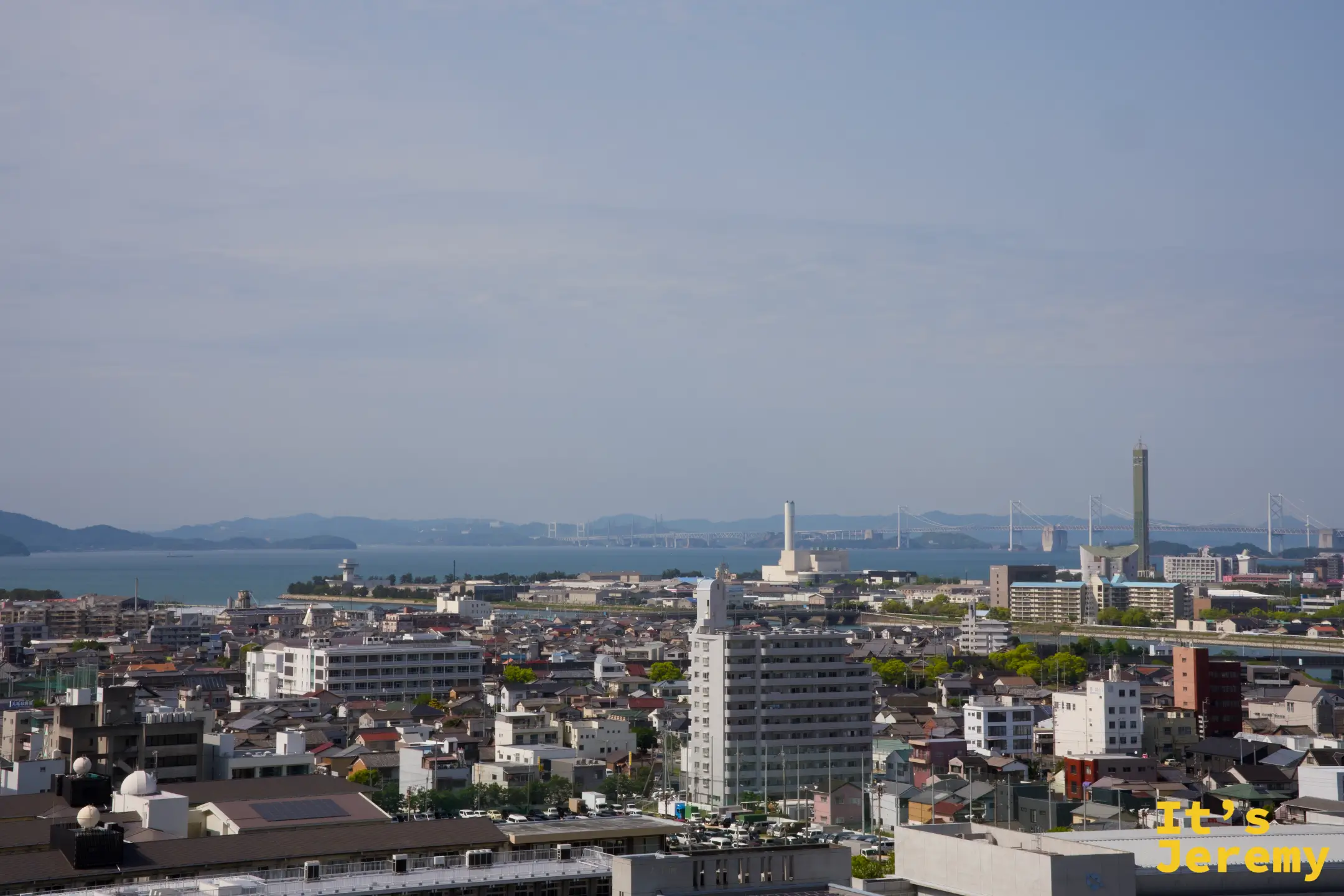 從城上可見瀨戶內海遠方的瀨戶大橋，兩座斜張橋塔隱約浮現在海面上