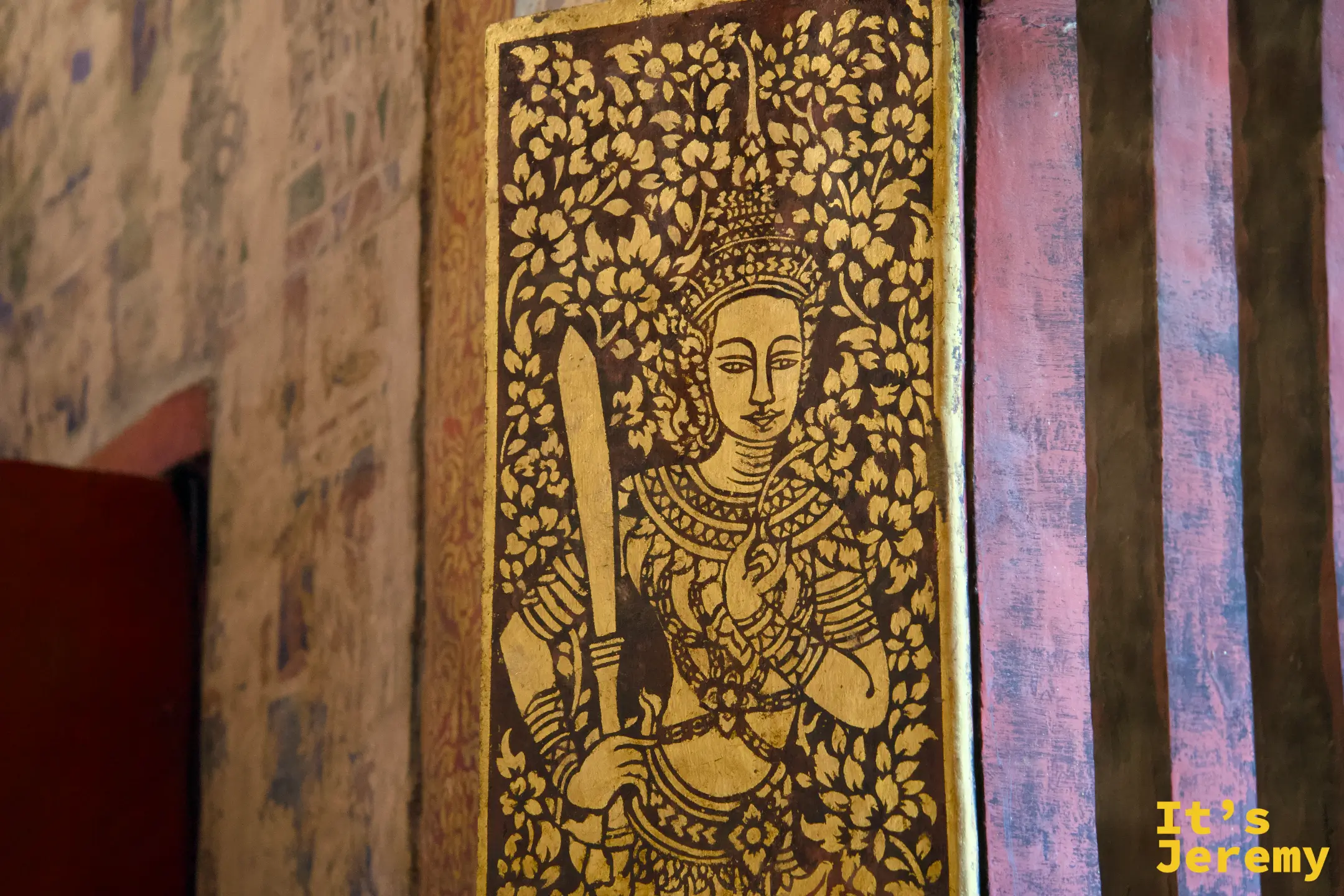 柱面木雕彩繪板，金色天神（武士）手持長劍，黑棕底金色花葉紋為背景