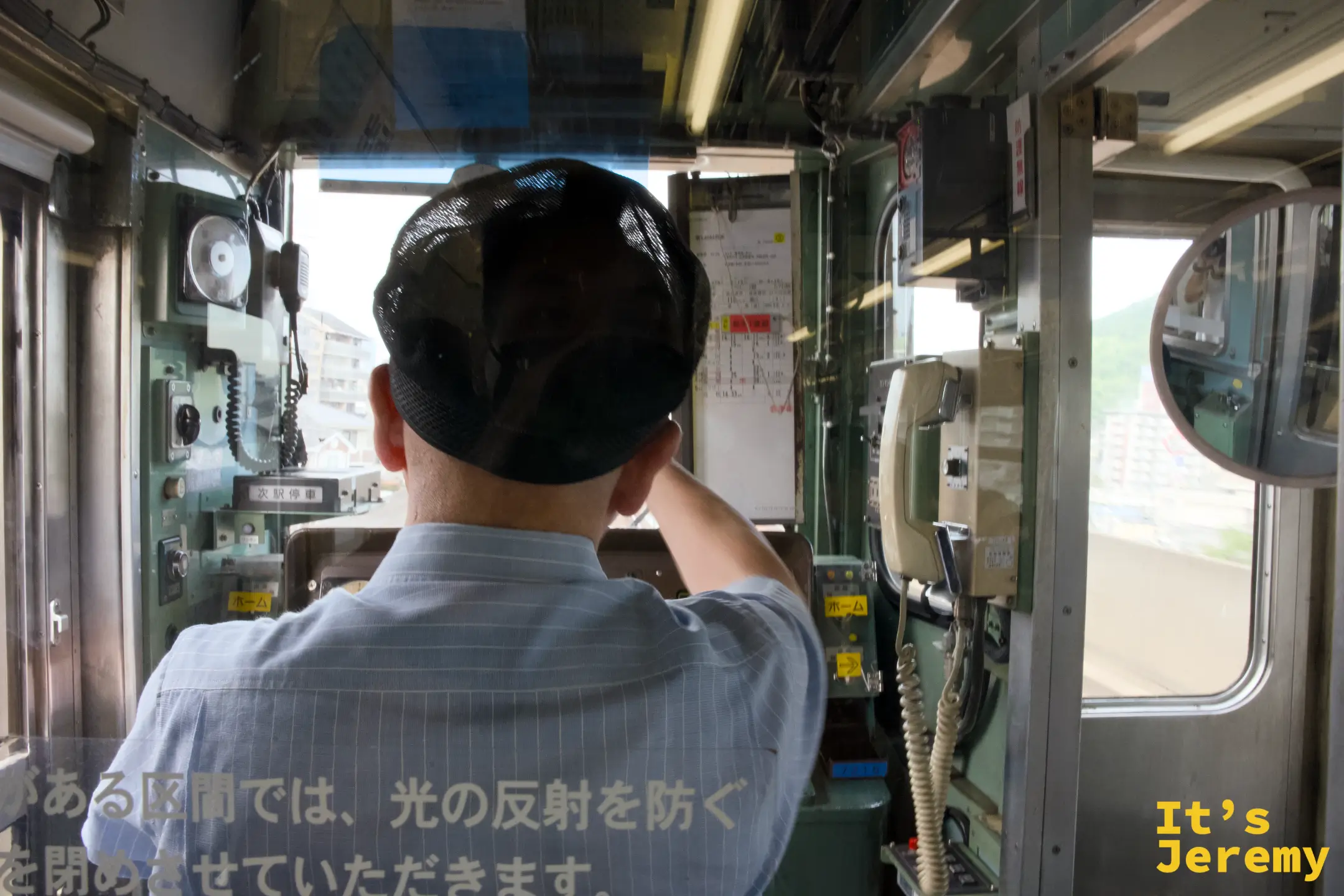 從麵包超人列車車廂內往駕駛艙望去，司機員正在確認安全，車窗玻璃上貼有提示貼紙
