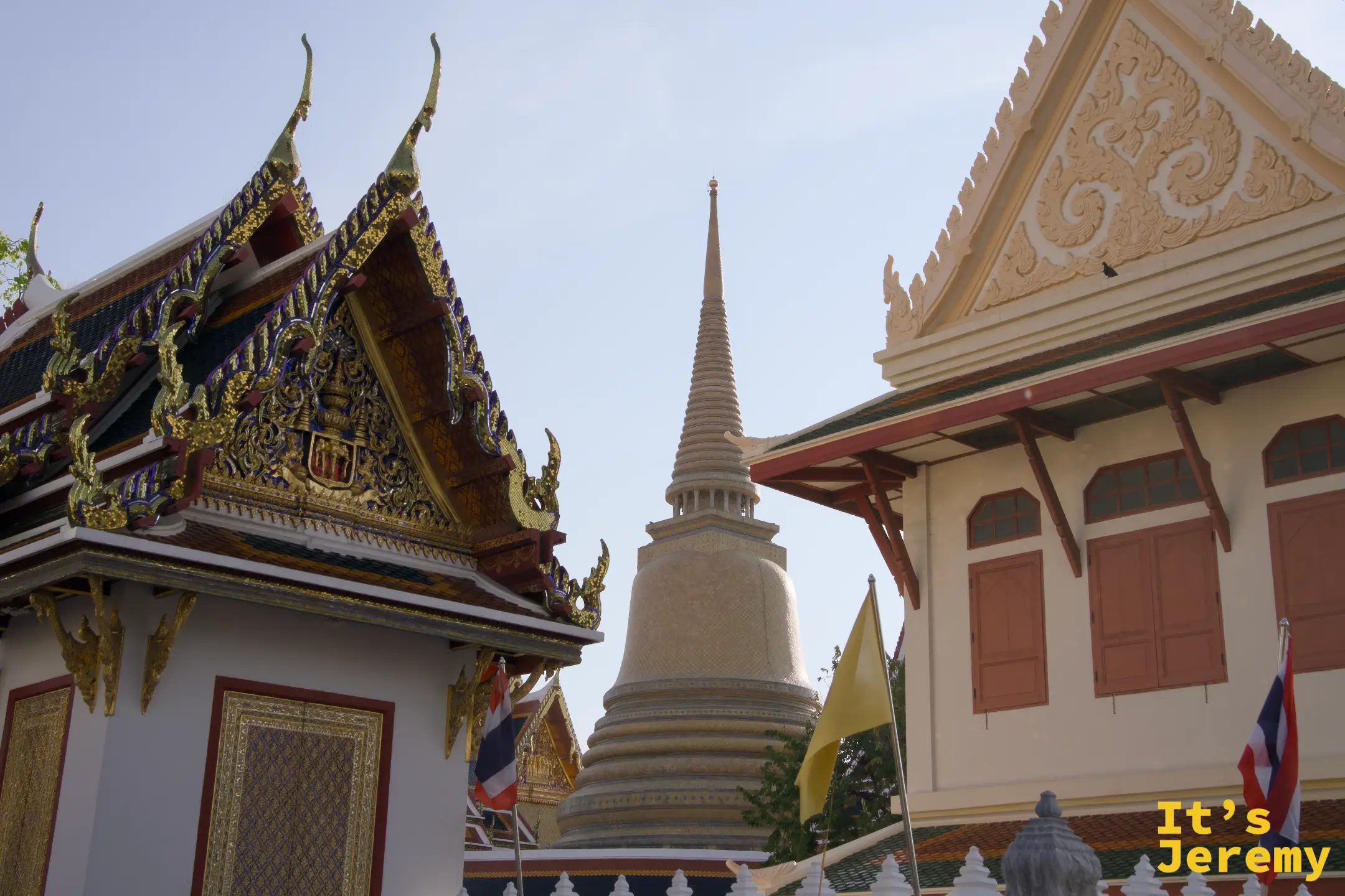 Wat Pho 的金色屋頂與白色佛塔尖端在兩棟建築之間冒出來，這天用「路過視角」帶過去