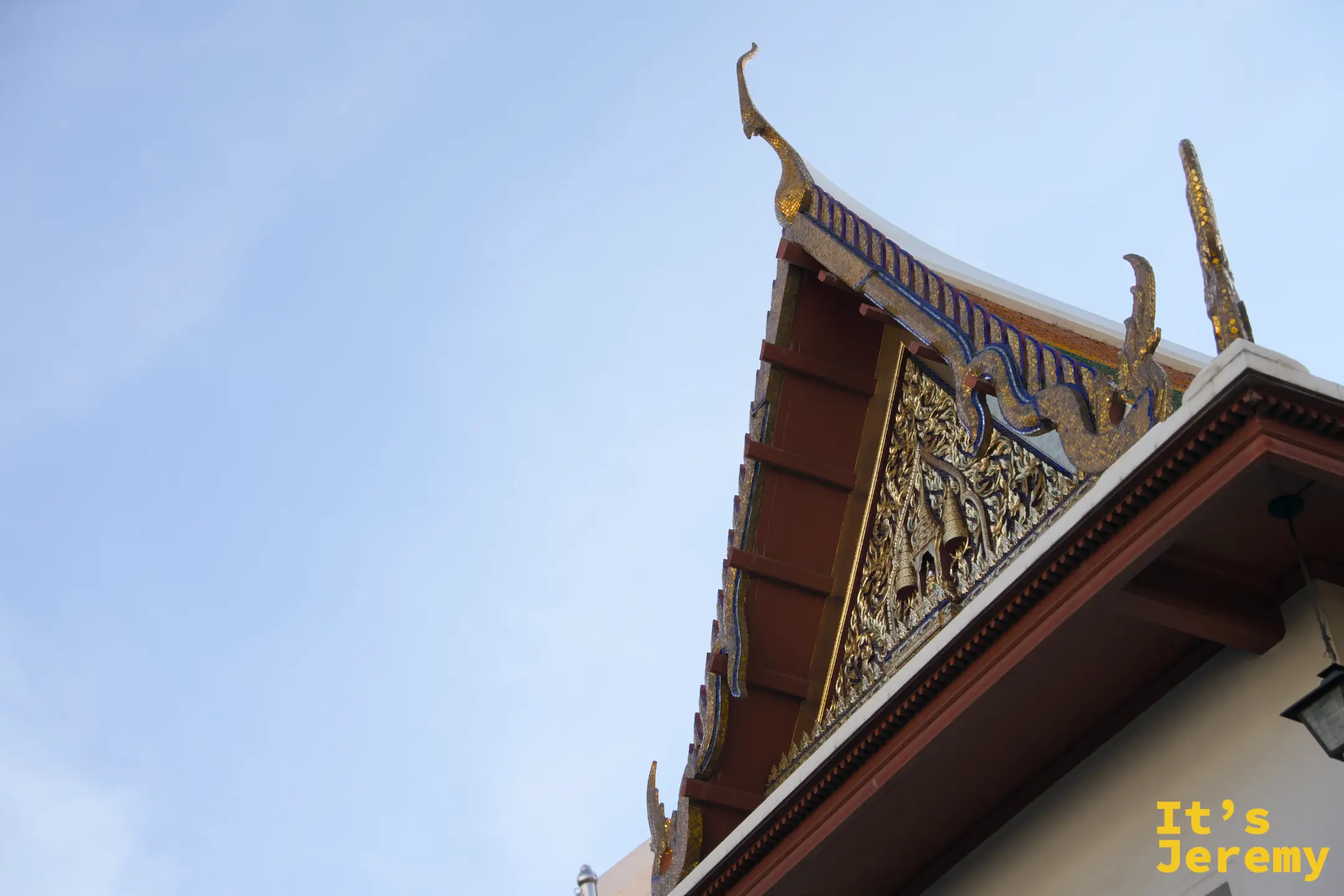 Wat Pho 的山牆與金色屋頂、藍天背景中刺出的山牆雕花特寫