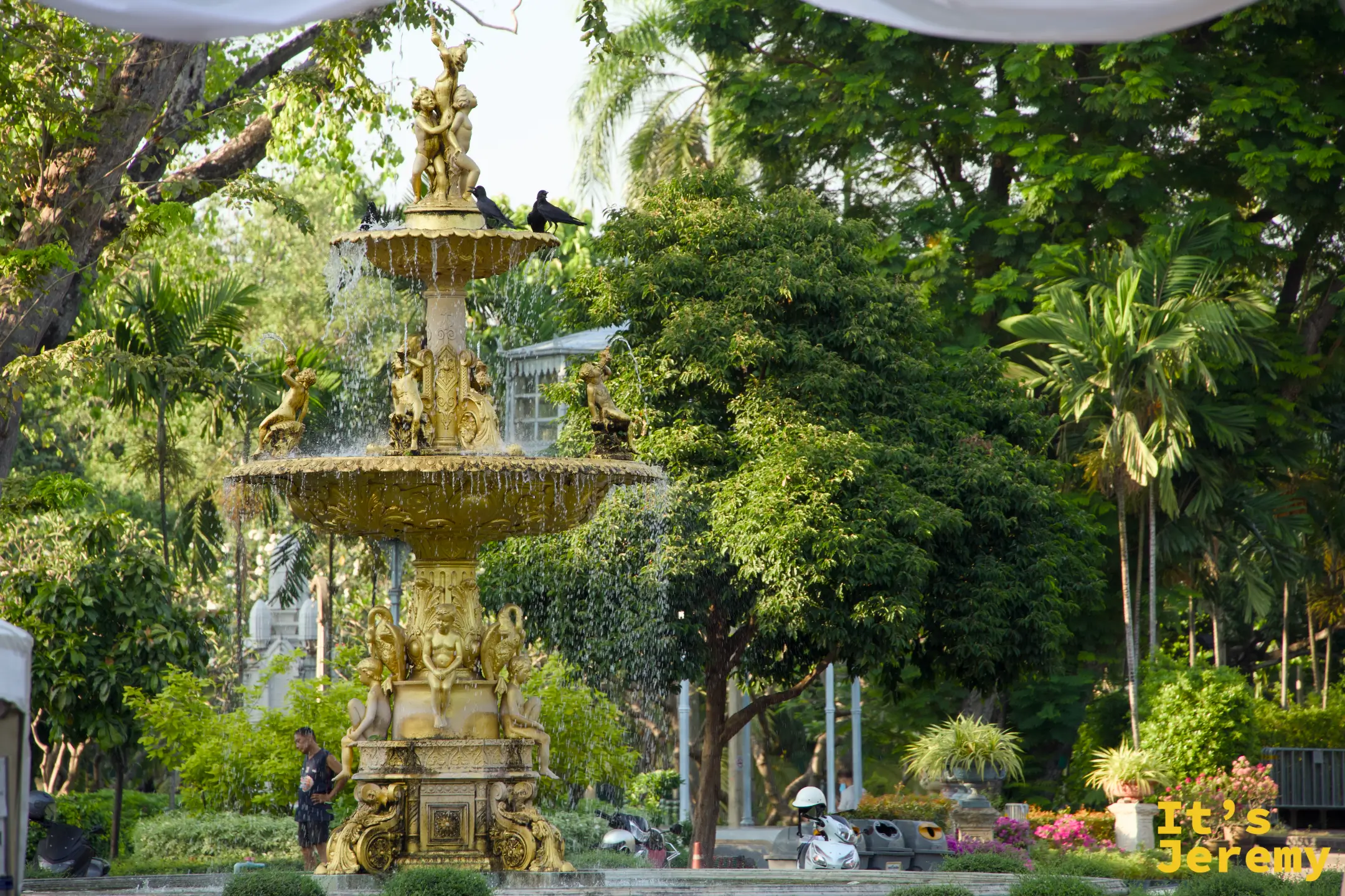 Saranrom Royal Garden 內的 1880 年代金色噴泉，灰色雕花石材在傍晚光裡帶著綠苔氣味