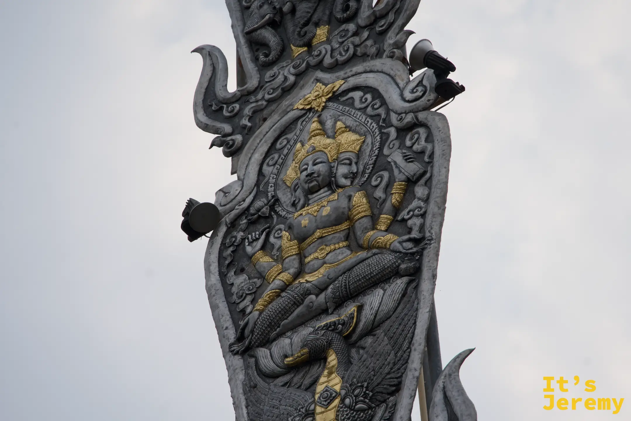 旗幡柱中段特寫，雙面神明浮雕面容細緻，金色裝飾搶眼