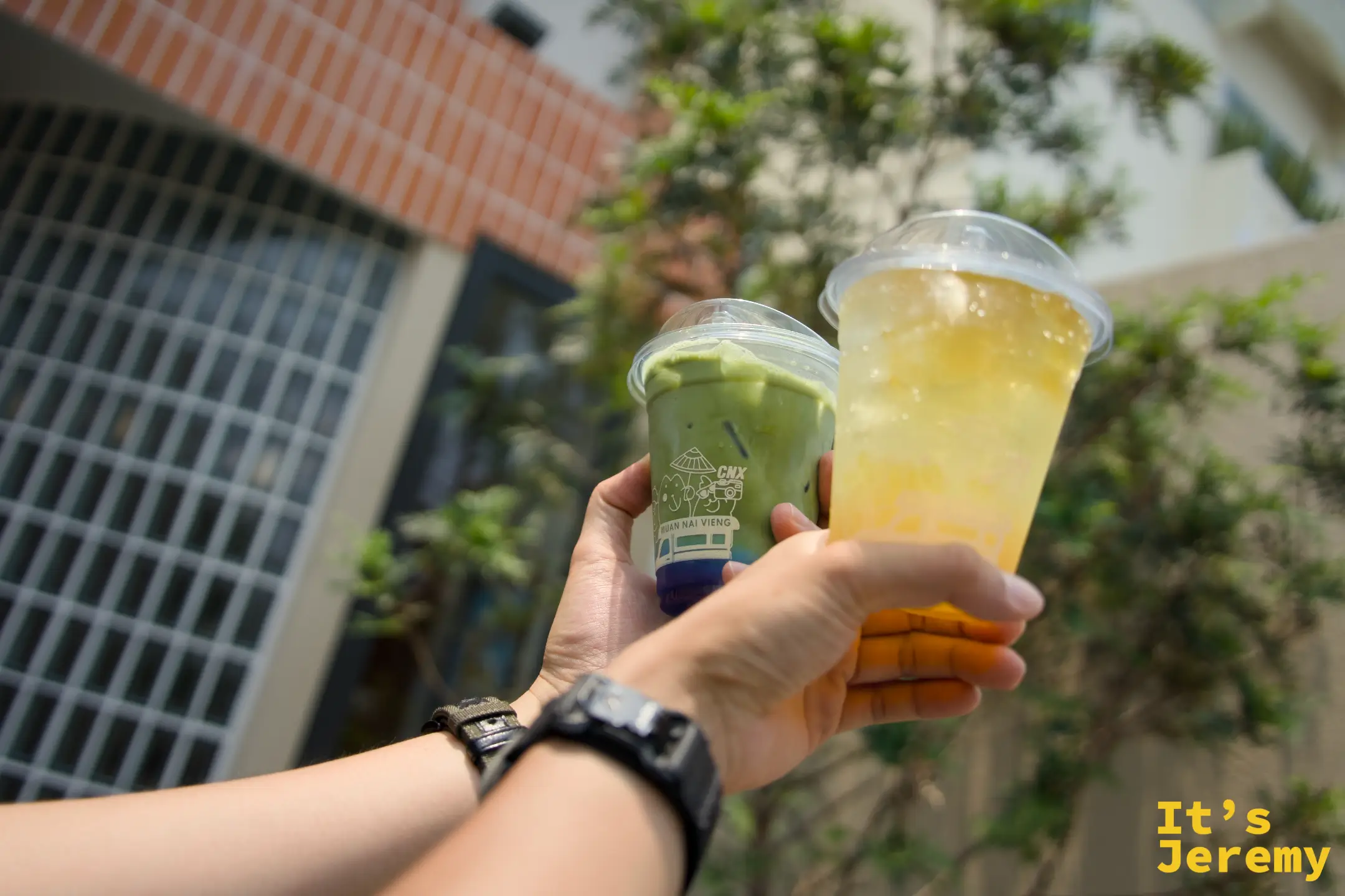 手持兩杯飲料：左邊抹茶歐蕾、右邊蜂蜜檸檬果凍氣泡飲