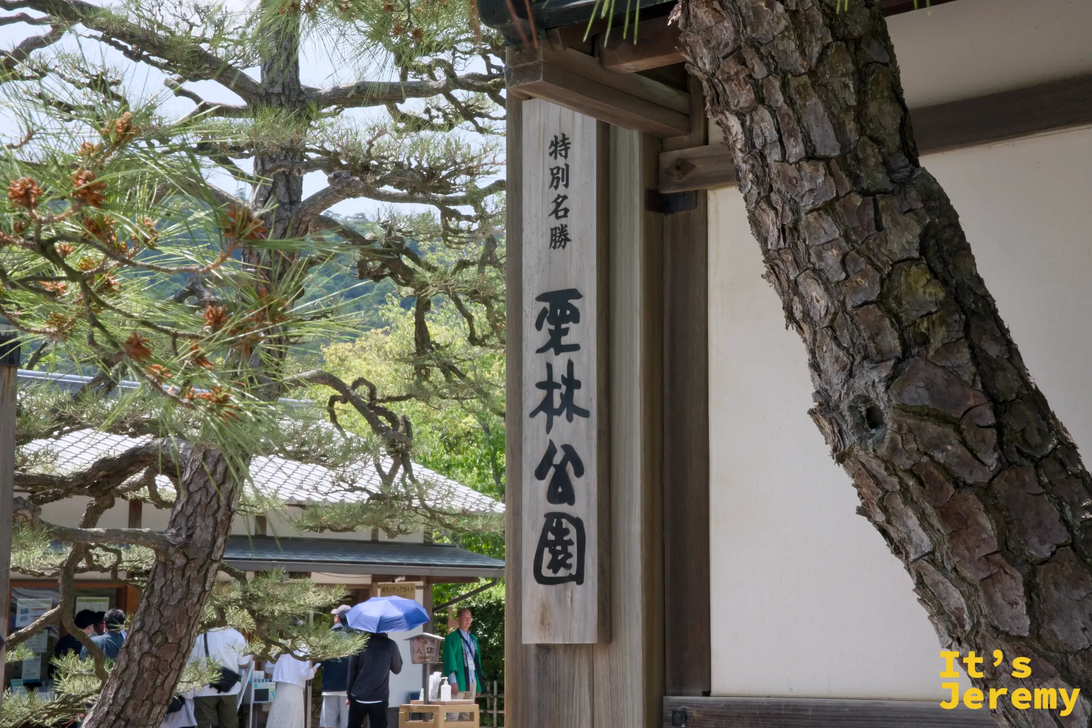 特別名勝 栗林公園的入口木牌，松枝從兩側延伸