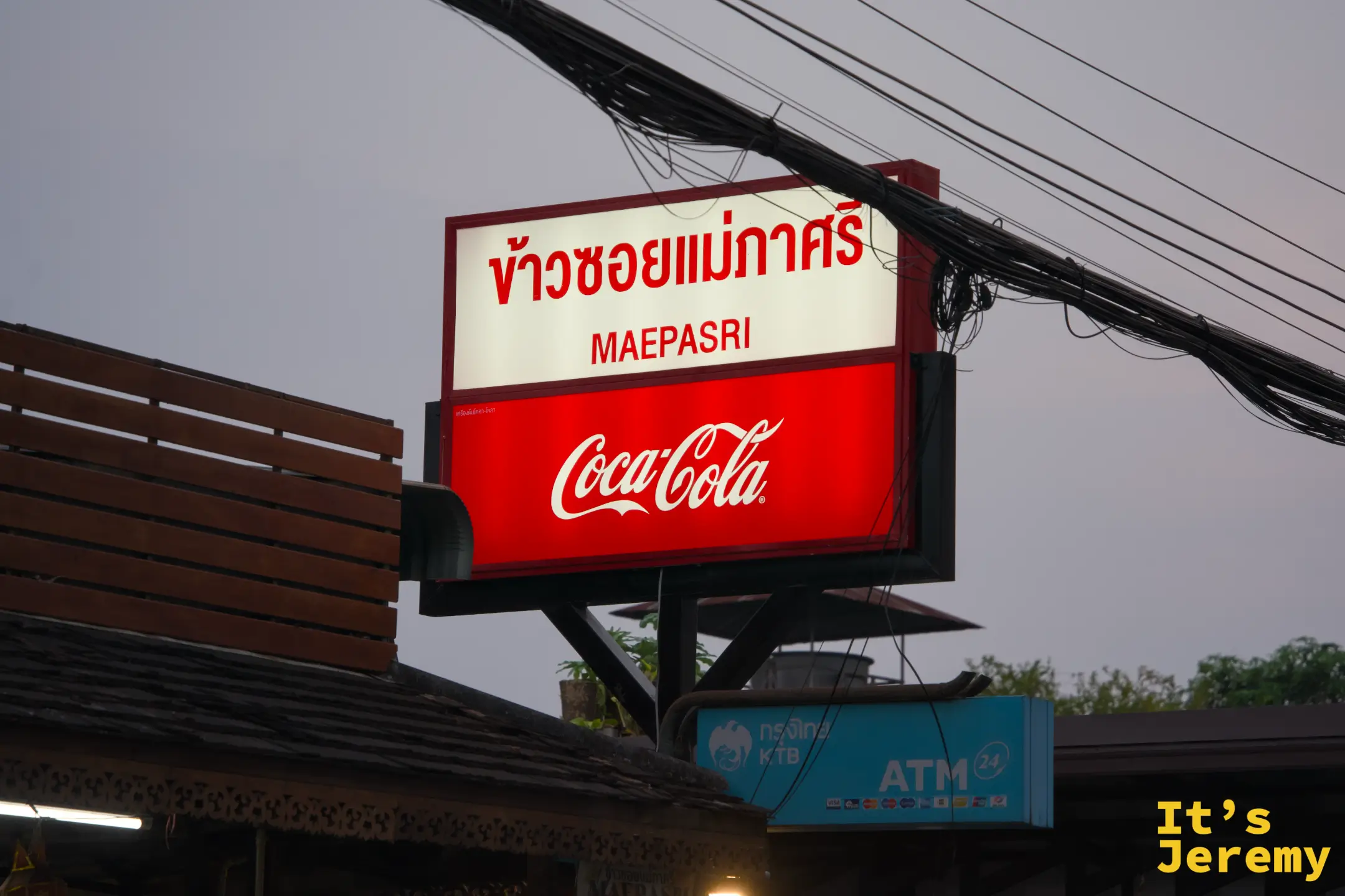 Mae Pa Sri ข้าวซอยแม่ภาศรี 的招牌夜景，紅白燈箱搭配 Coca-Cola 廣告板