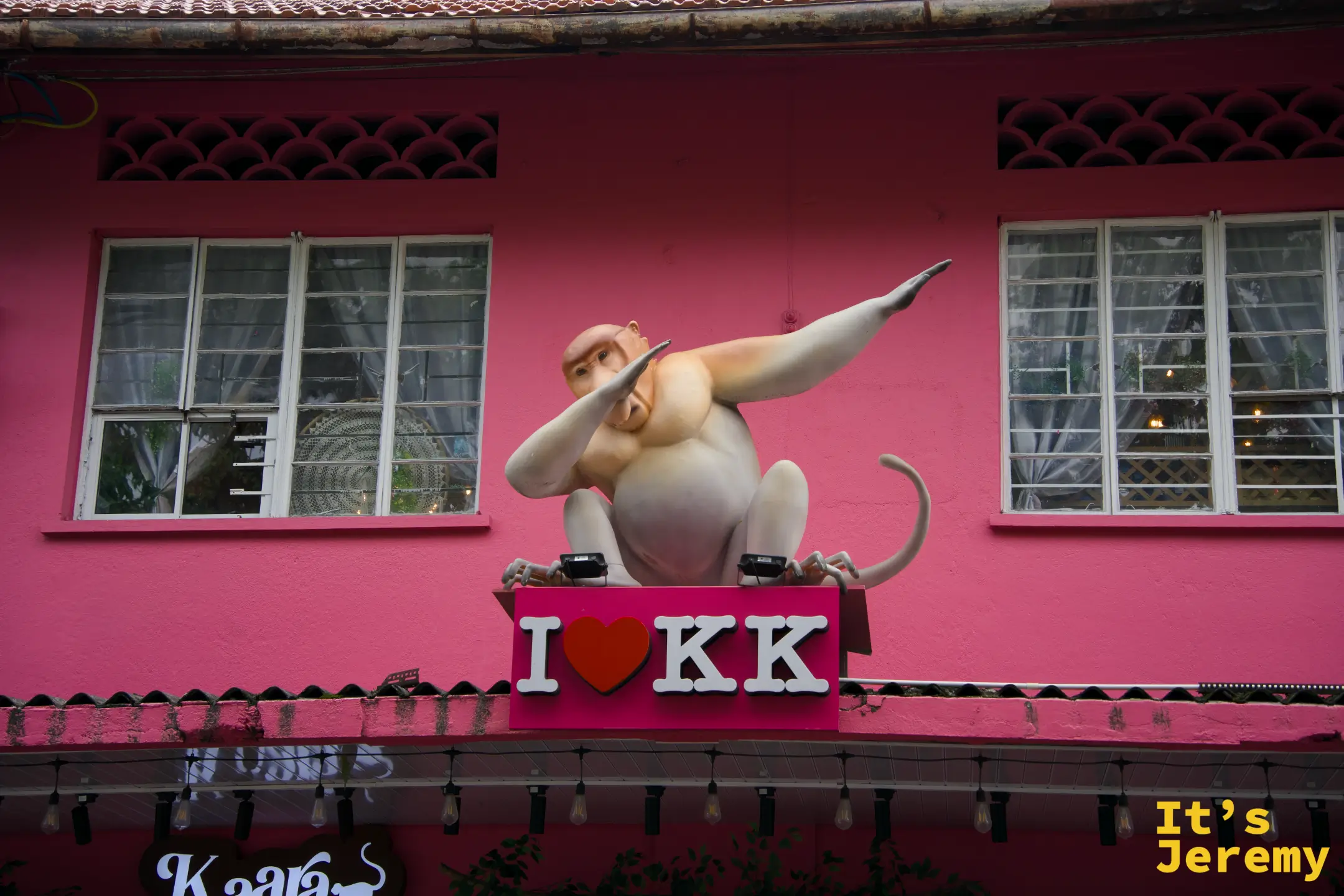 「I ❤ KK」招牌特寫，長鼻猴雕像做出 dab 動作