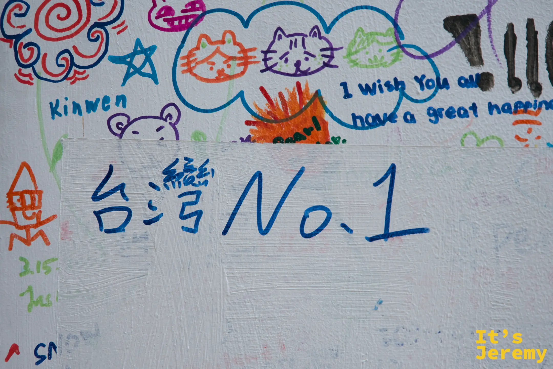 留言板特寫，藍筆寫著大大的「台灣No.1」，周圍是貓咪塗鴉與英文祝福