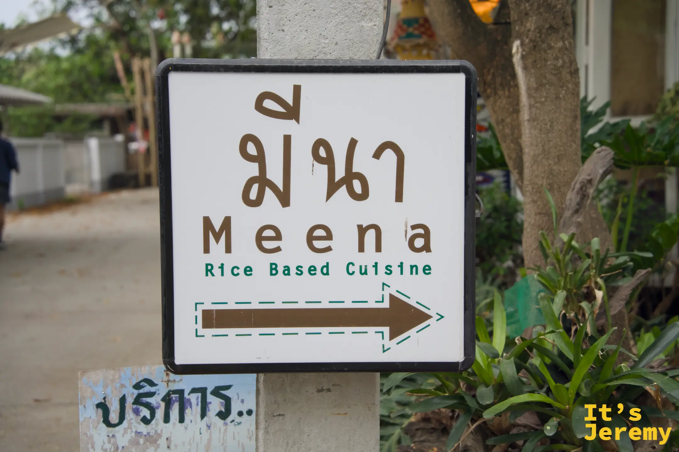 白色立牌上的 Meena 指路牌，泰文 มีนา 配英文與咖啡色箭頭