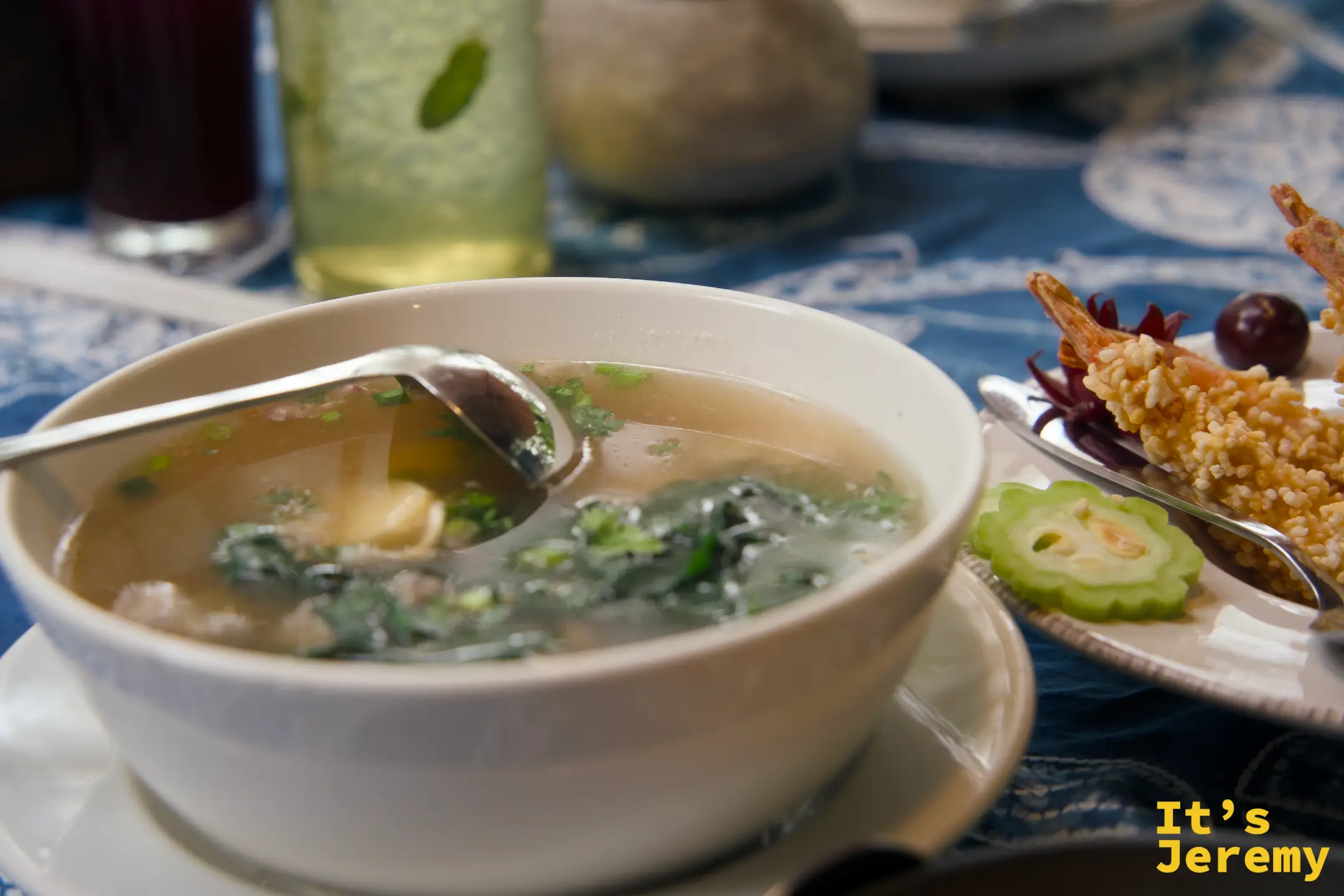 豬肉丸紅瓜葉湯，白瓷碗裡的清湯浮著綠色菜葉，湯杓架在碗緣