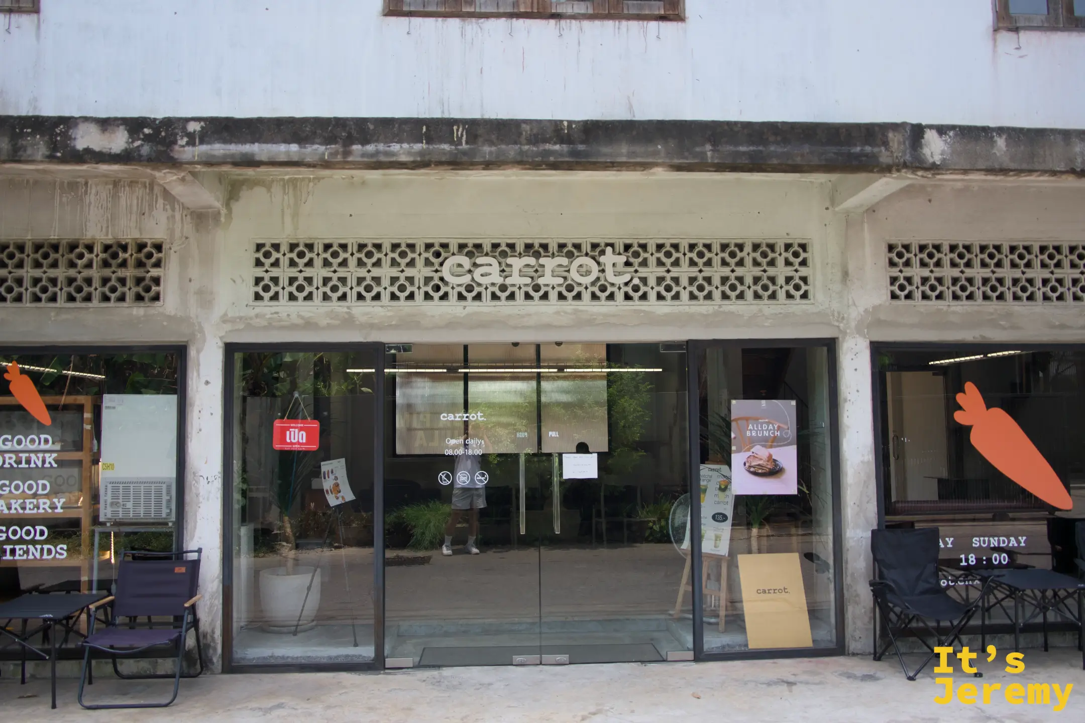 Carrot Coffee CNX 店面外觀，通風磚立面嵌著 carrot 字樣，玻璃門兩側擺著露營椅