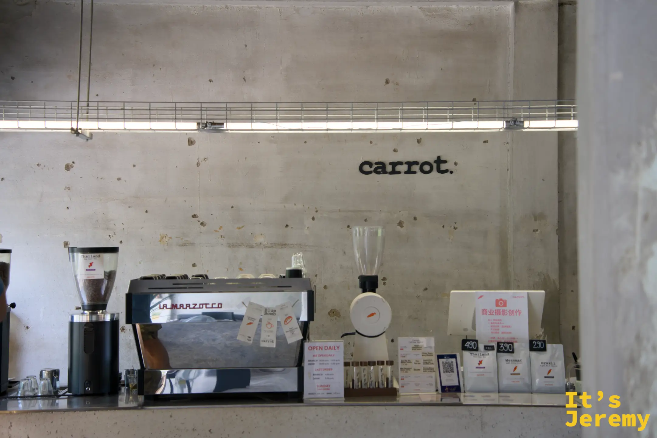 吧台全景，La Marzocco 義式機、胡蘿蔔磨豆機與牆上的 carrot. 字樣