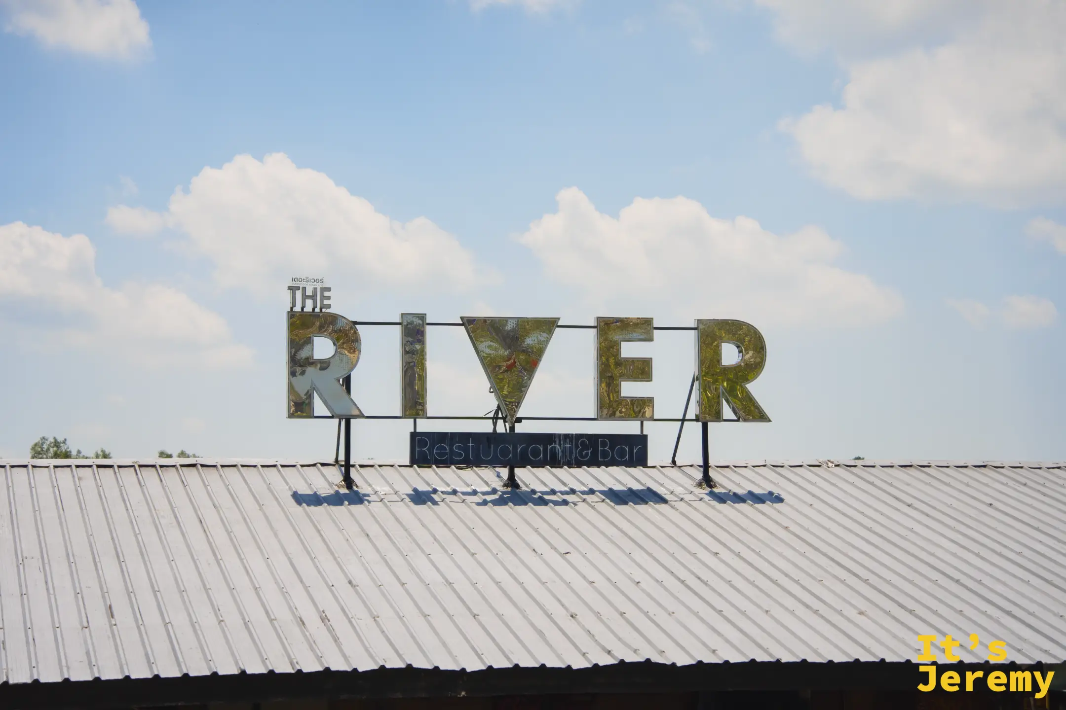 The River Restaurant & Bar 招牌，白天藍天下的大字