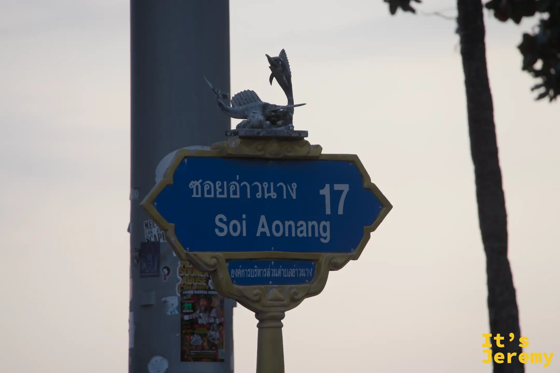 Soi Aonang 17 路牌，路牌頂端有旗魚雕像，傍晚天色泛橘