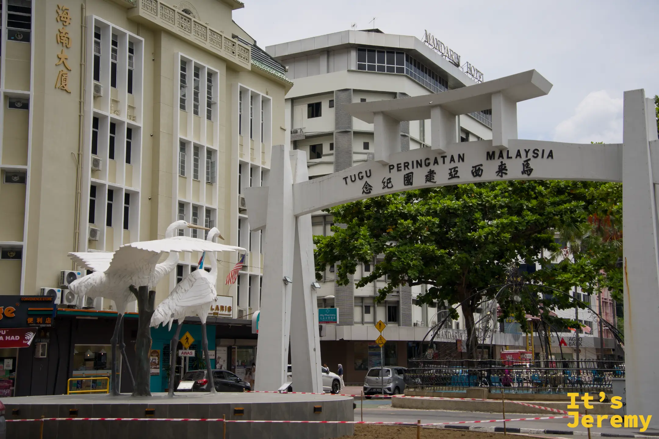 馬來西亞紀念碑（Tugu Peringatan Malaysia），白色拱門與白鷺雕像，背景為海南大廈