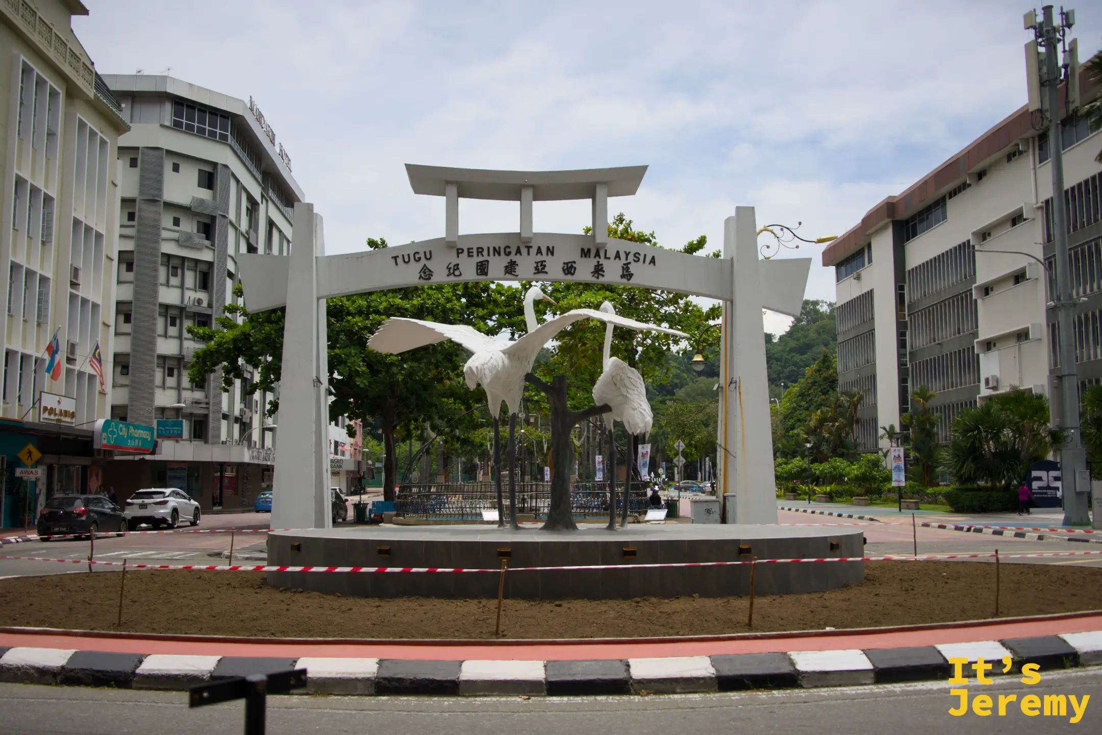 馬來西亞紀念碑正面，拱門與白鷺雕塑全景，TUGU PERINGATAN MALAYSIA 字樣清晰