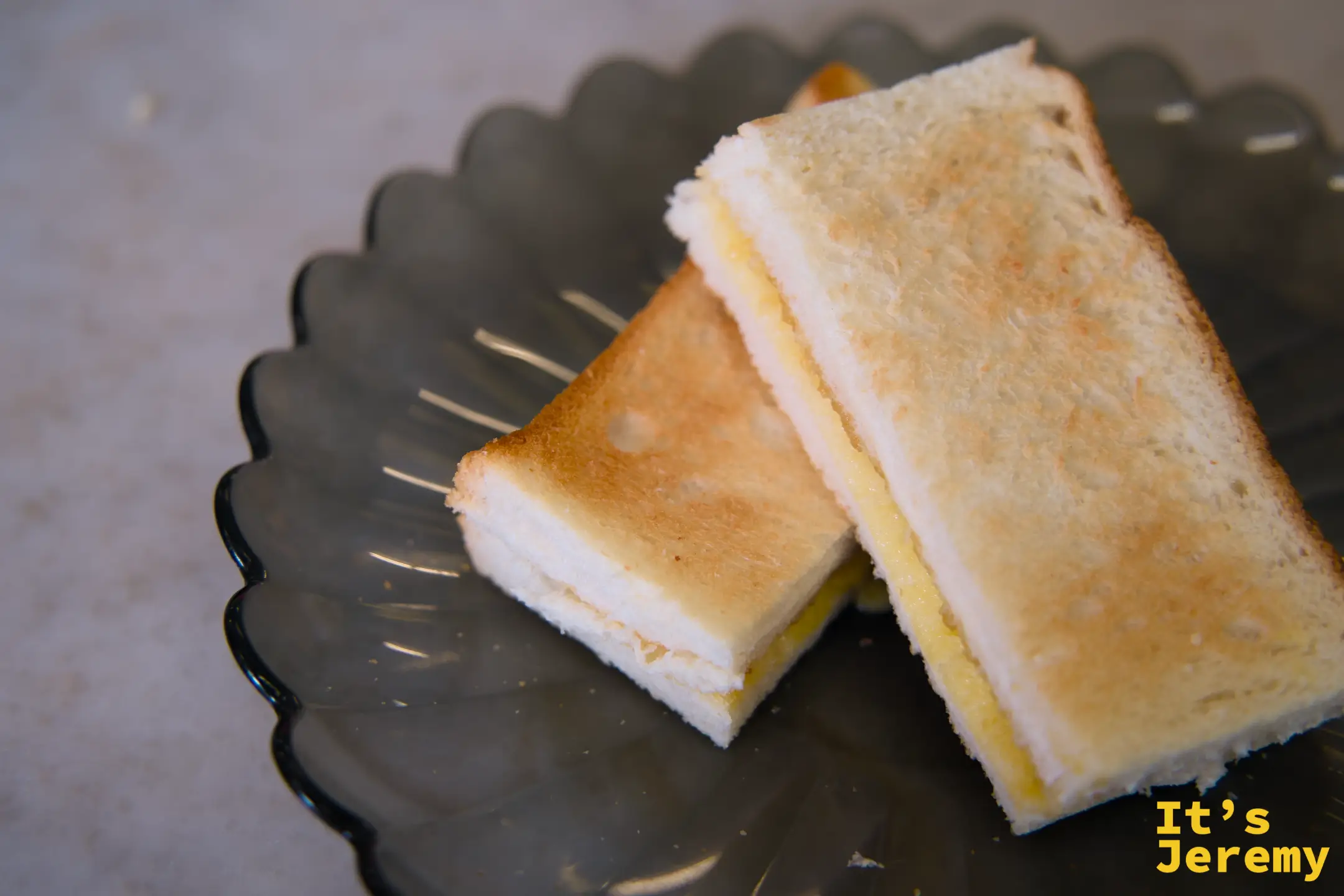 兩片三角切的 Kaya Toast，金黃色椰漿醬清晰可見