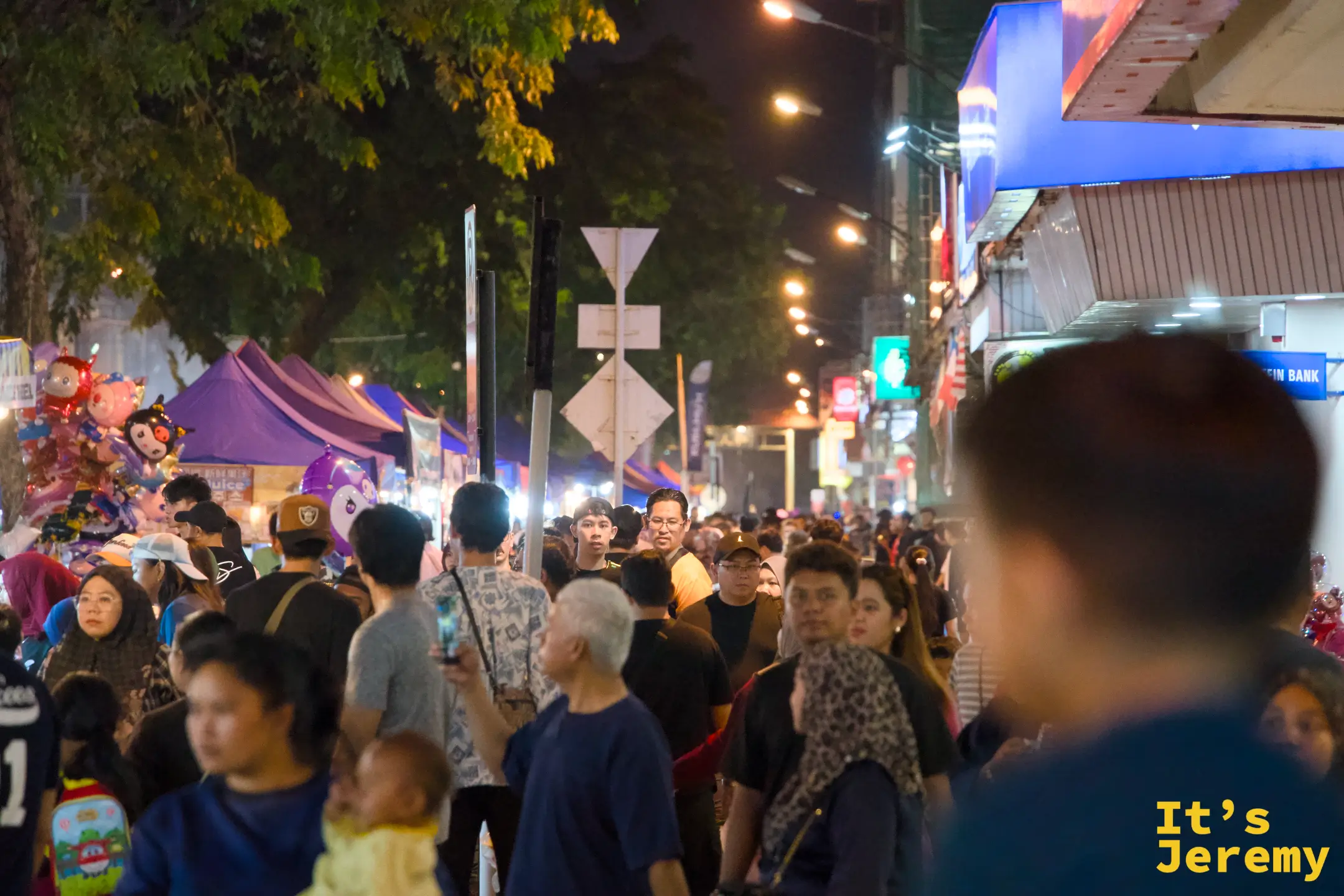 加雅街夜市夜晚全景，整條街道密集地擠滿了行走的人群，兩側帳篷攤位延伸至遠處