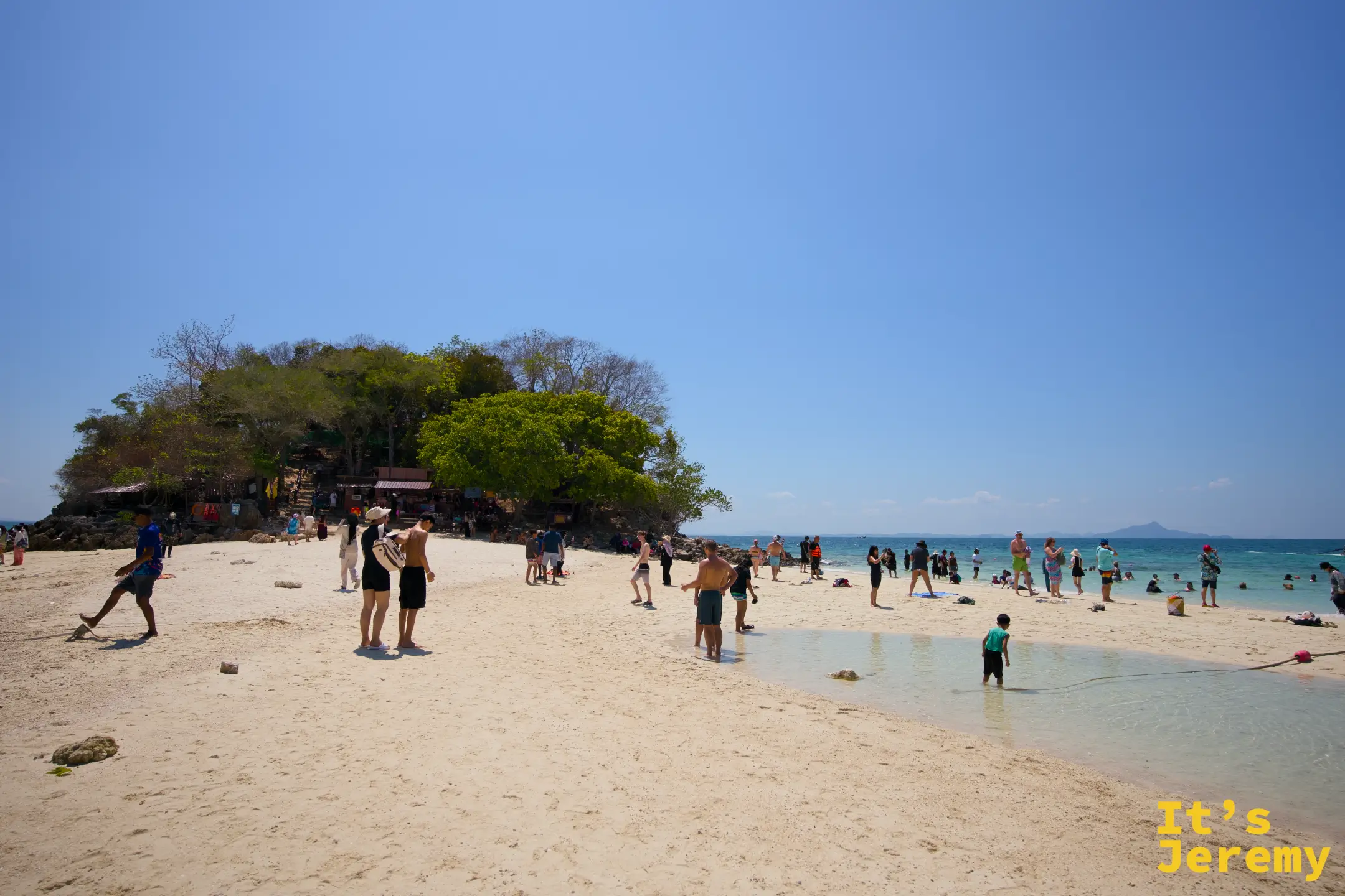 沙洲全景，白沙連接小島，大批遊客在沙洲上活動
