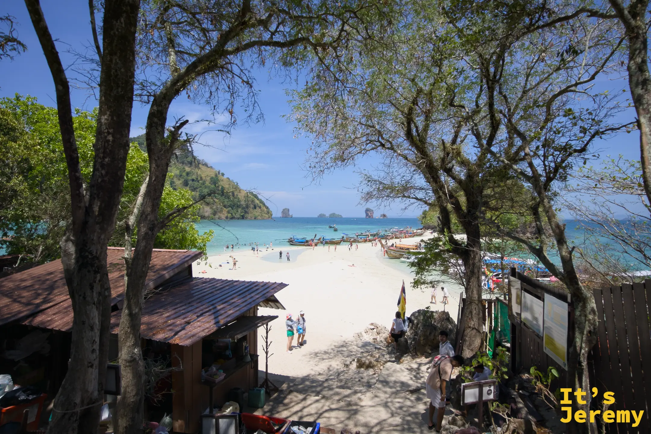 從小島制高點往下俯瞰沙洲與海灘全景，遠方可見長尾船