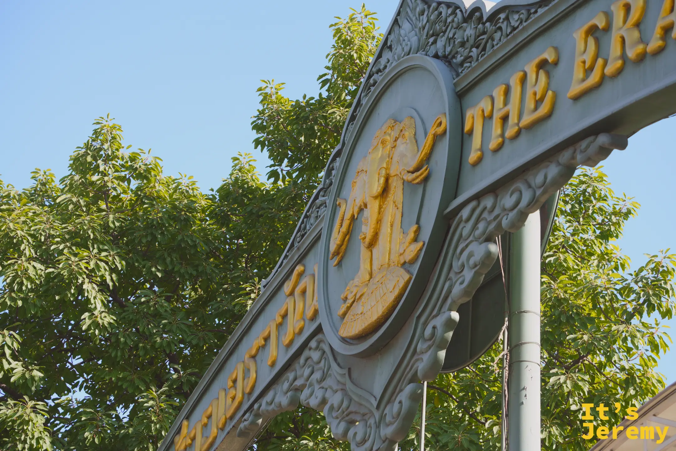 博物館入口大牌坊特寫，金色 The Erawan 字樣與洛可可雕飾