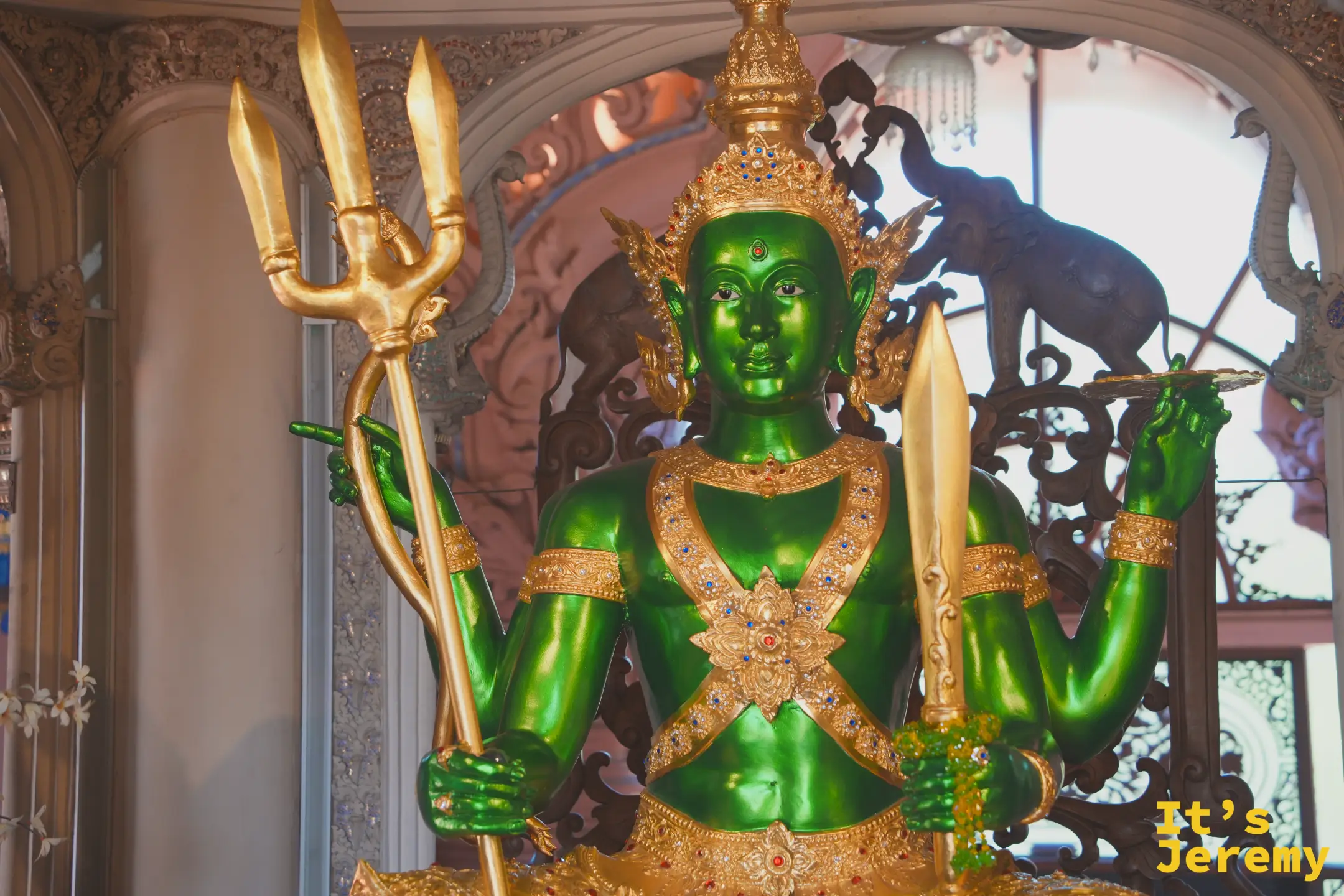 象腹正中央的翡翠綠四臂神祇雕像，背後是印度教神話浮雕