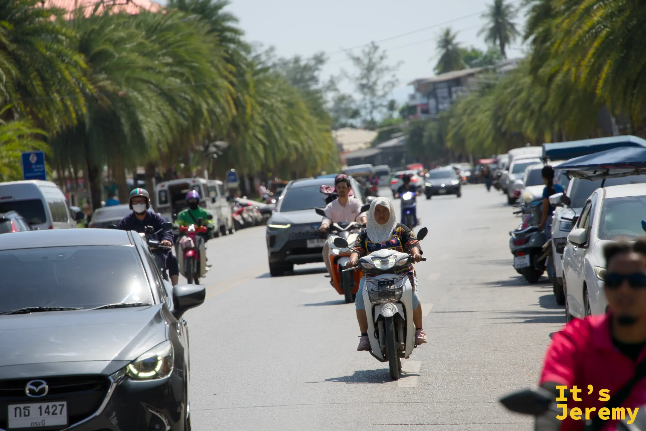 雙條車行進中，窗外是喀比郊區街道，路旁是一般住宅與小店
