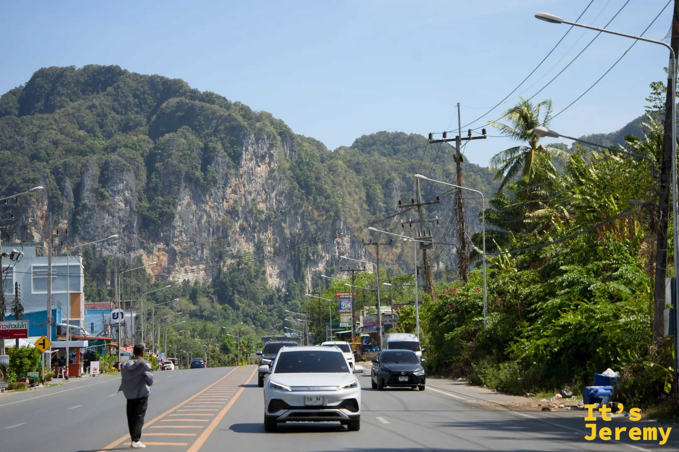 從雙條車後車廂往外看，公路延伸向前，遠方是喀比的石灰岩山脈輪廓