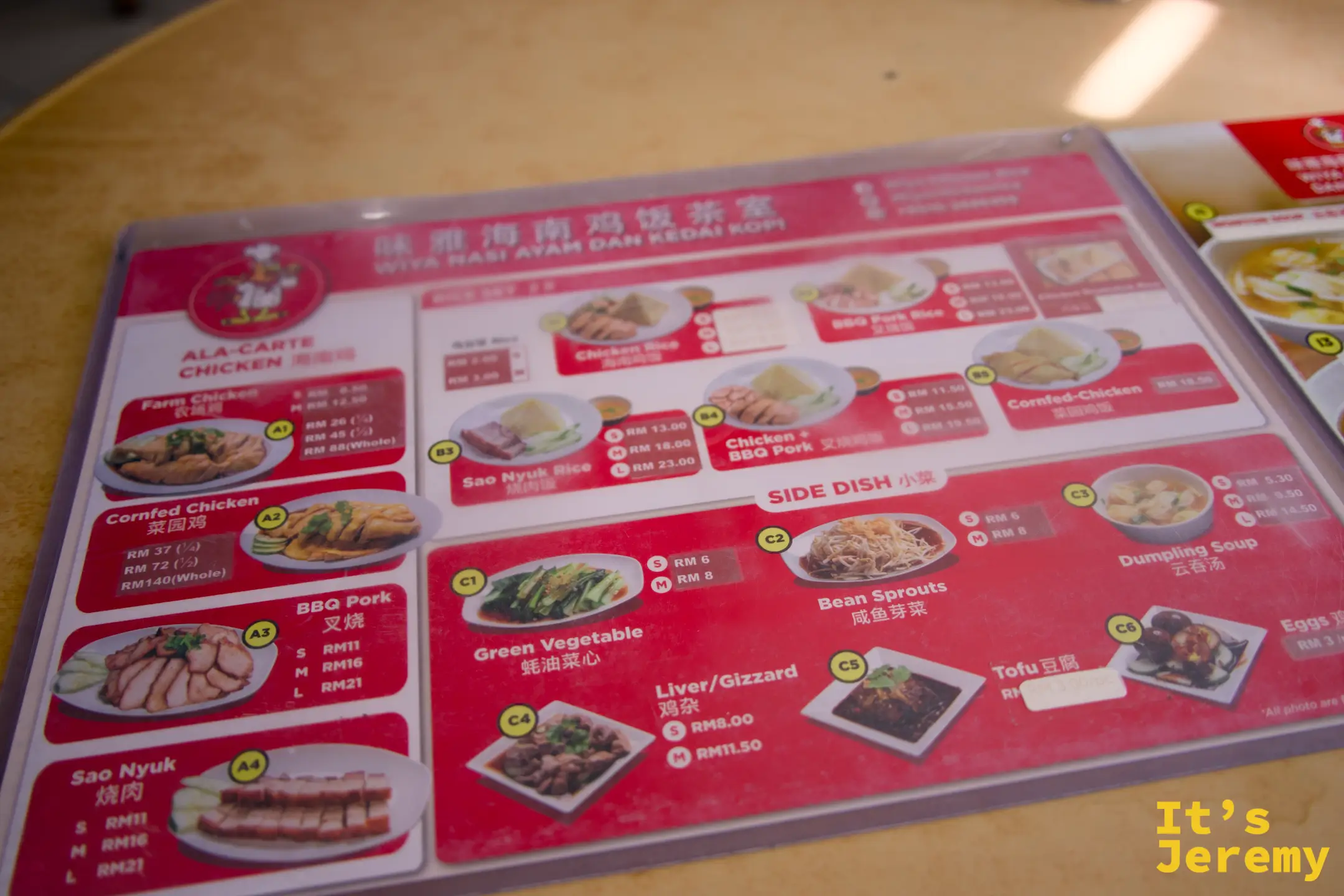 桌上的護貝菜單，以圖片標示各種雞肉選項、小菜與分量，中英對照