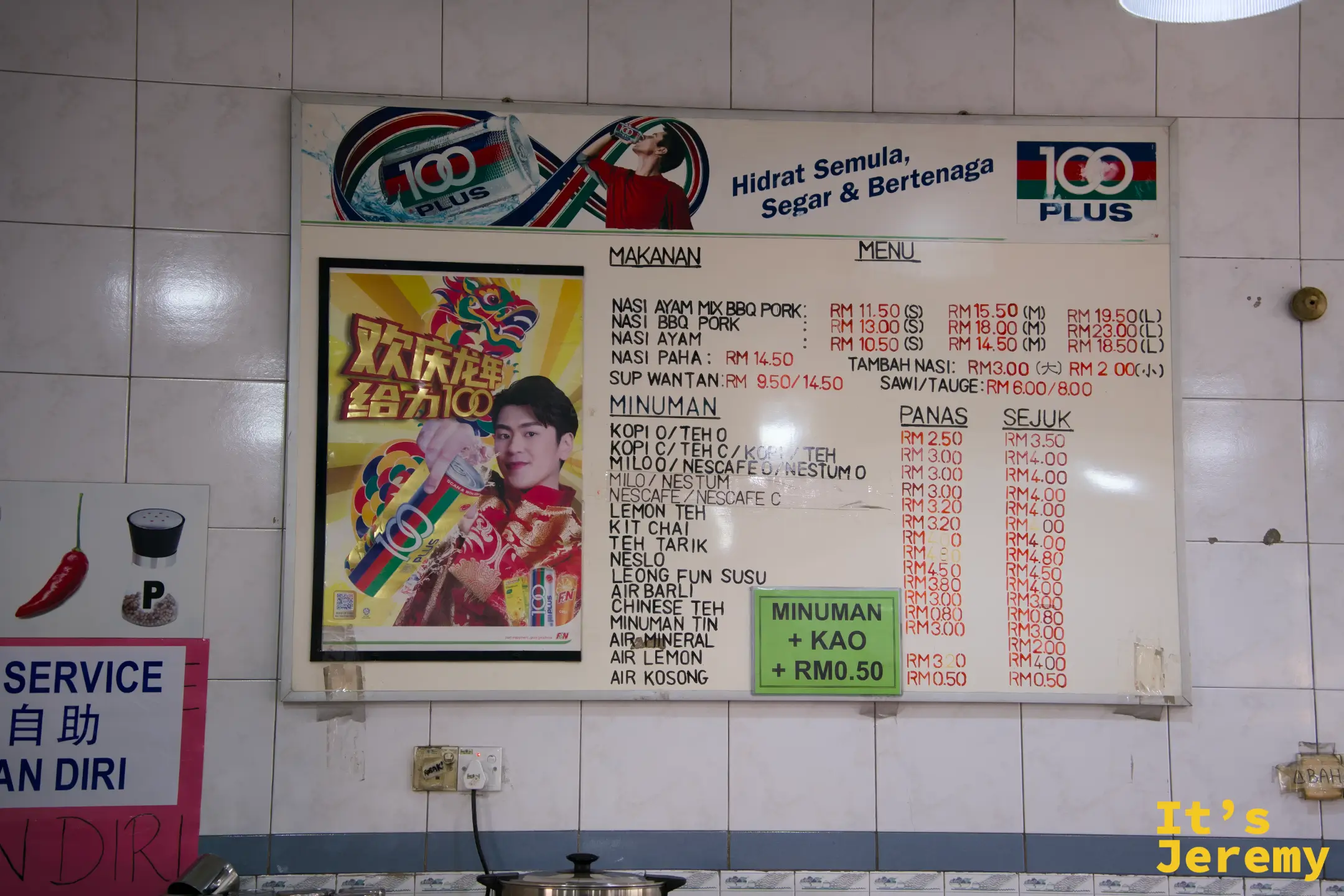 牆上的手寫菜單板，列出馬來文主食名稱、飲料種類與冷熱價格