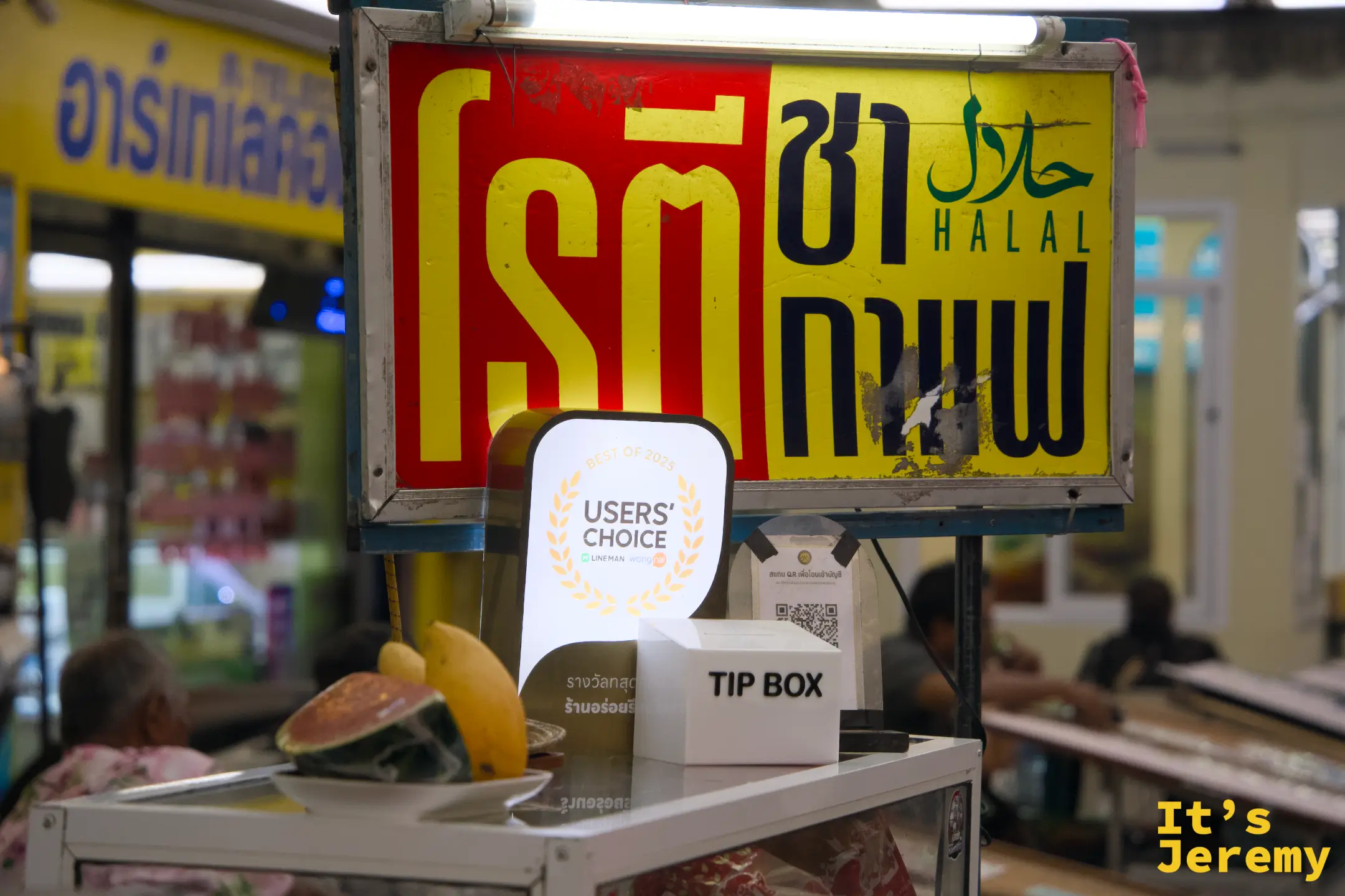 招牌紅底黃字寫著「โรตี ชา กาแฟ」，Halal 標誌掛在一旁，攤前還有 Lineman 2025 年度 Users