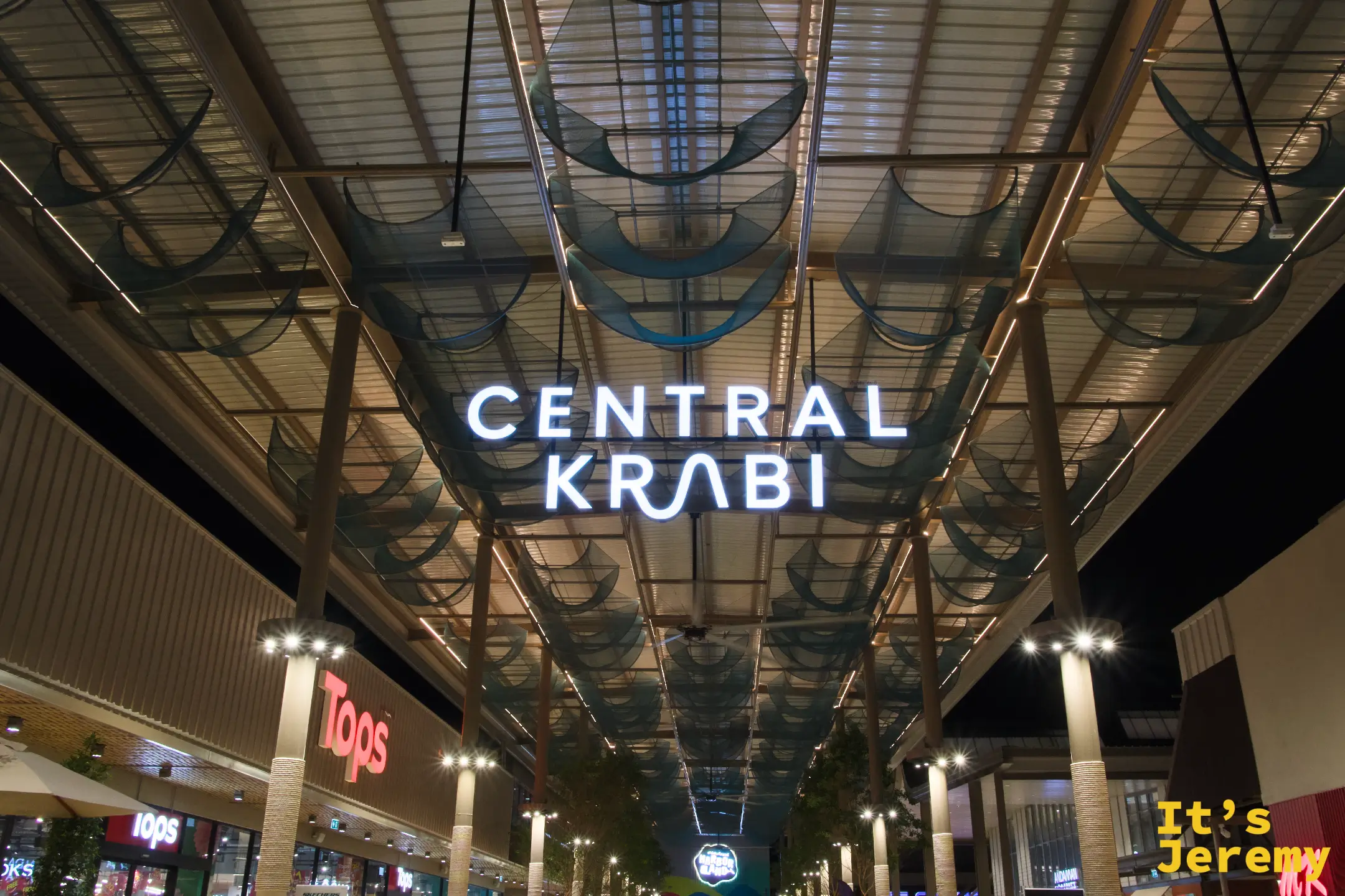 Central Krabi 室內入口走廊夜景,頂部有半圓形弧狀裝飾,兩側可見 Tops 招牌