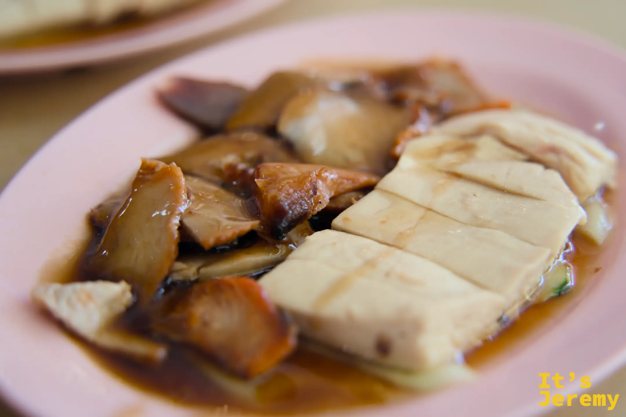 叉燒雞飯特寫：白切雞塊與叉燒切片並排於粉紅盤上，淋著深色醬汁