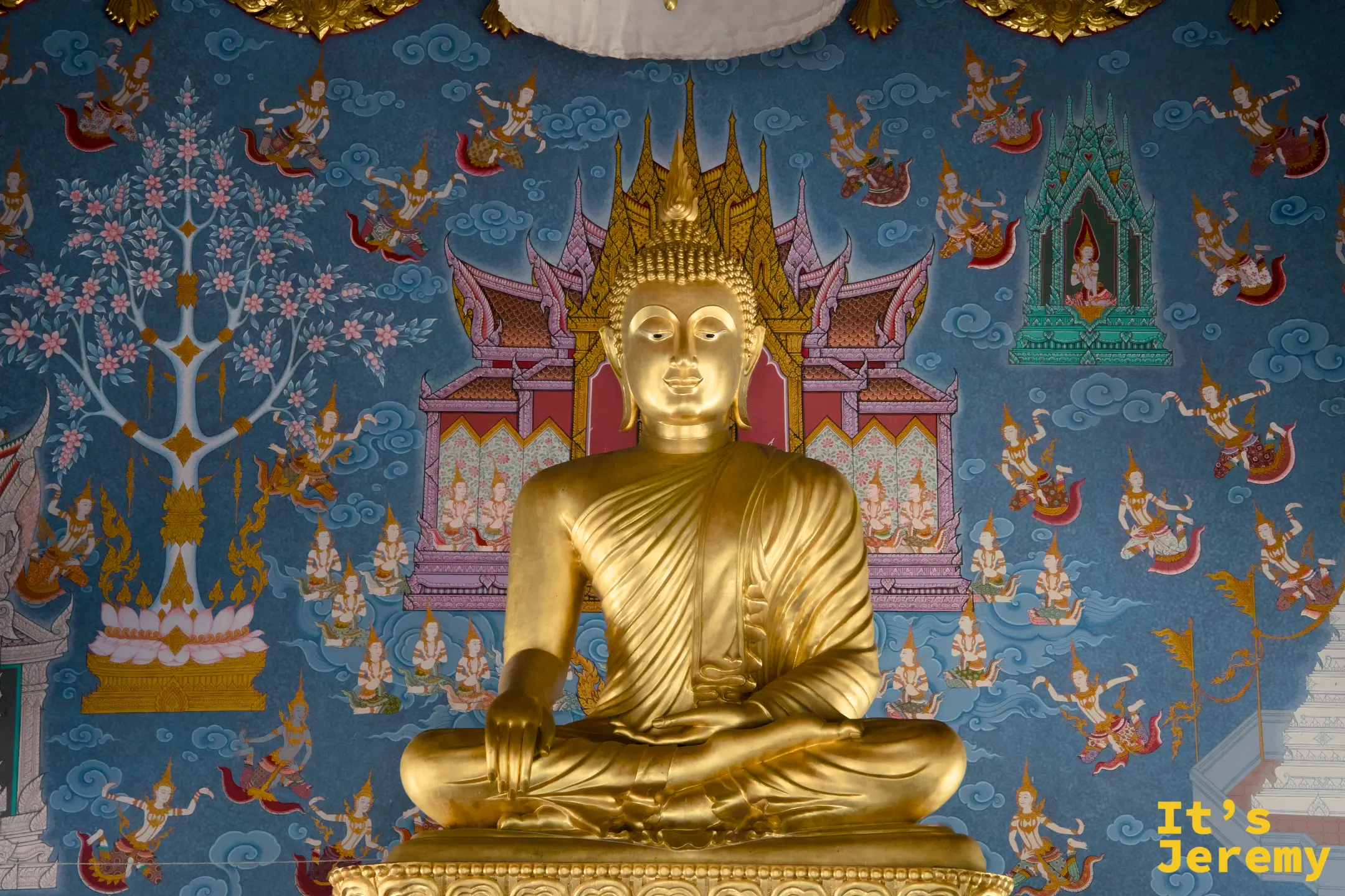 主殿內部金色坐佛,藍色天界壁畫為背景,佛像以觸地印姿態端坐正中