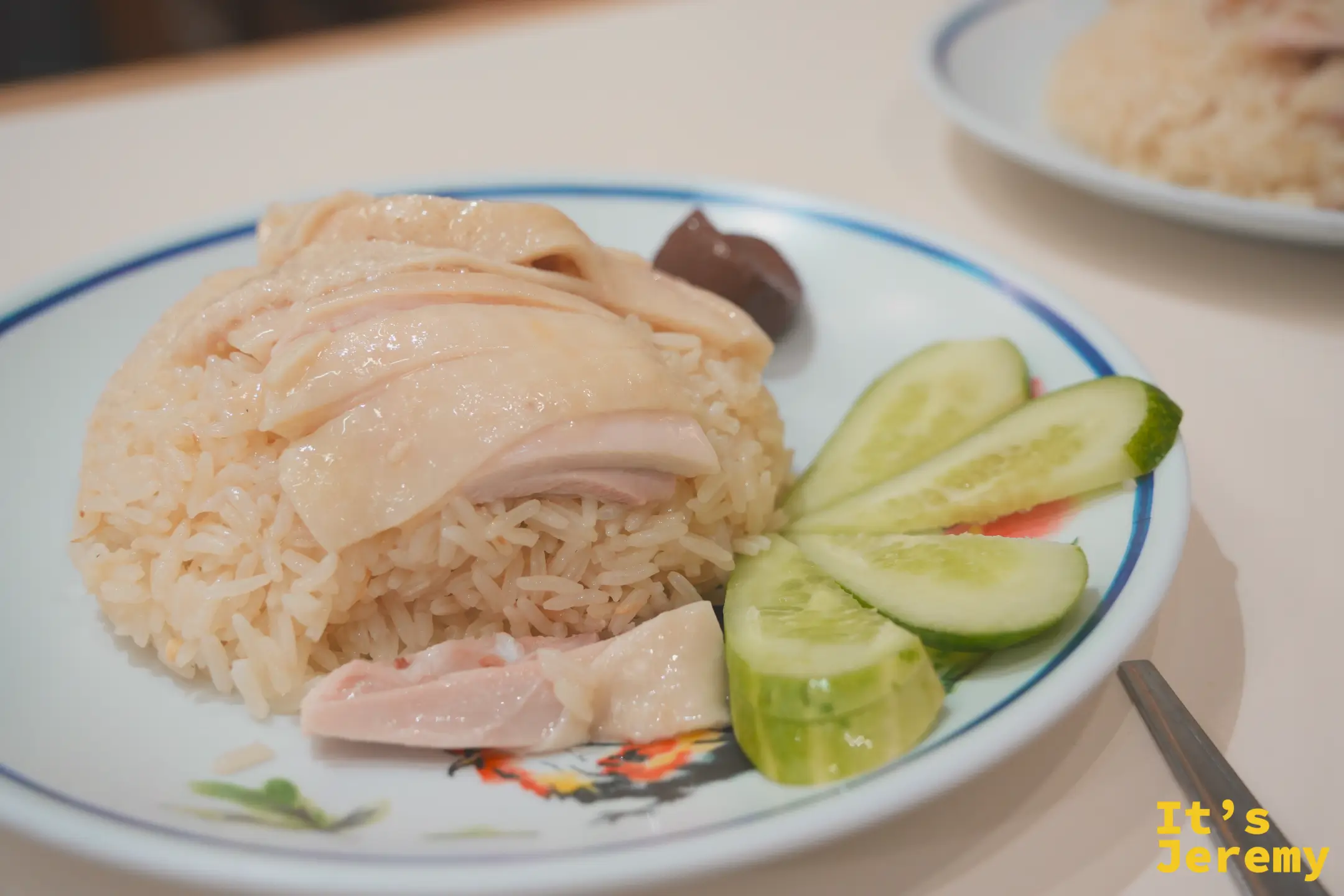 紅大哥海南雞飯特寫：白切雞蓋住黃油飯、配小黃瓜與豬血糕