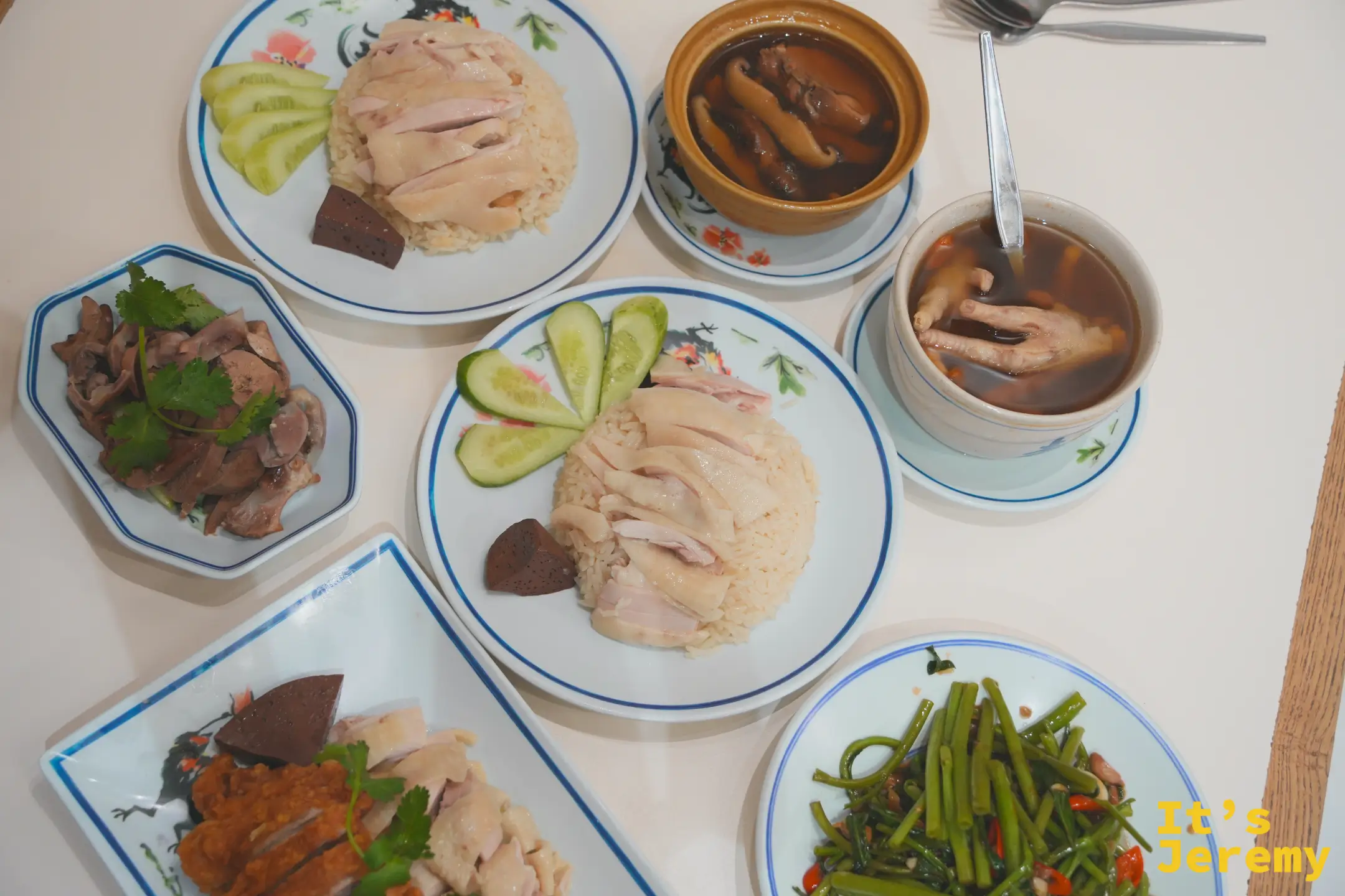 紅大哥兩盤海南雞飯上桌俯拍，配湯品、雞雜與空心菜
