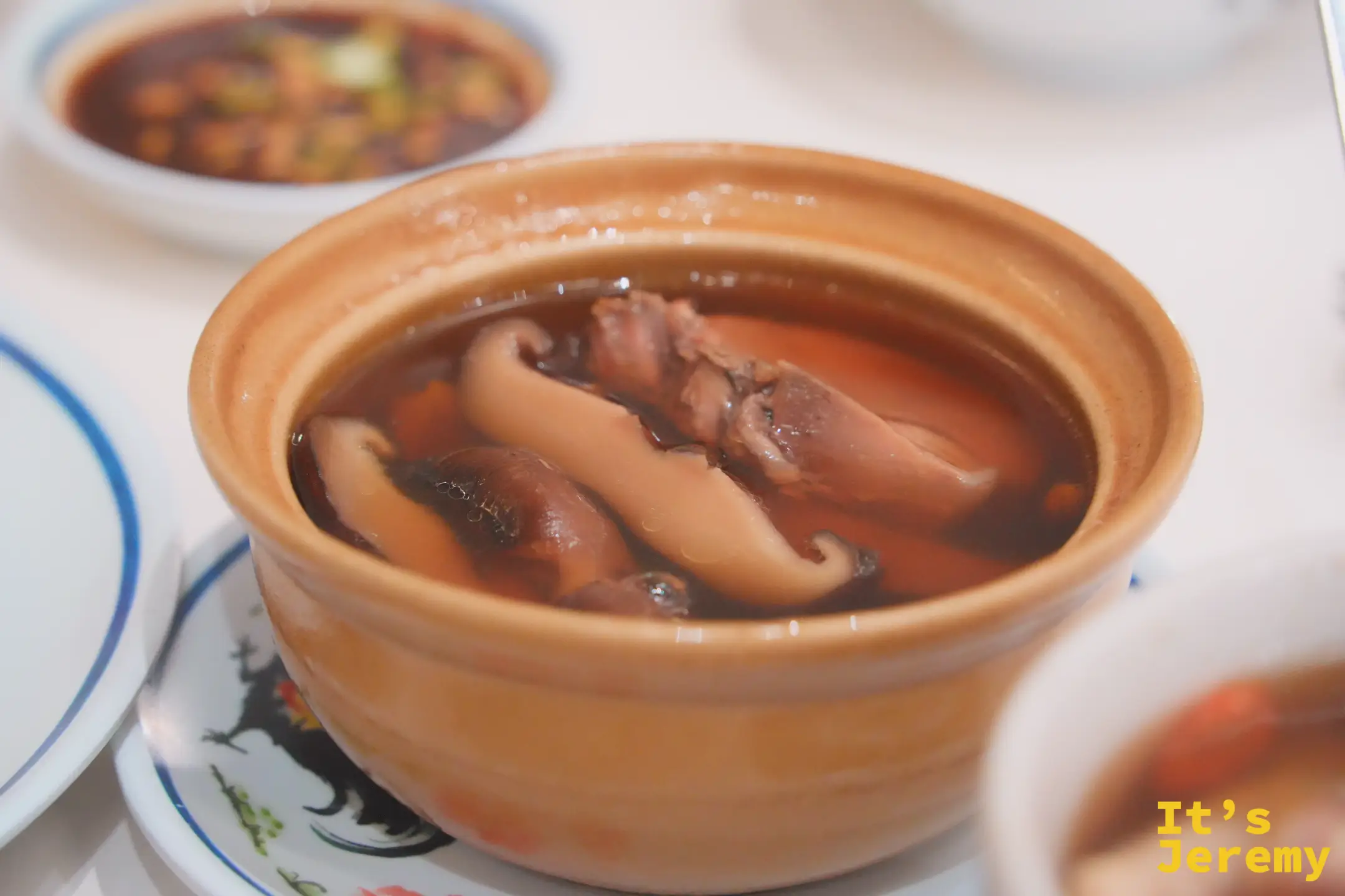 紅大哥香菇燉雞湯特寫：黃色小砂鍋裡的肥厚香菇與雞肉、湯色琥珀