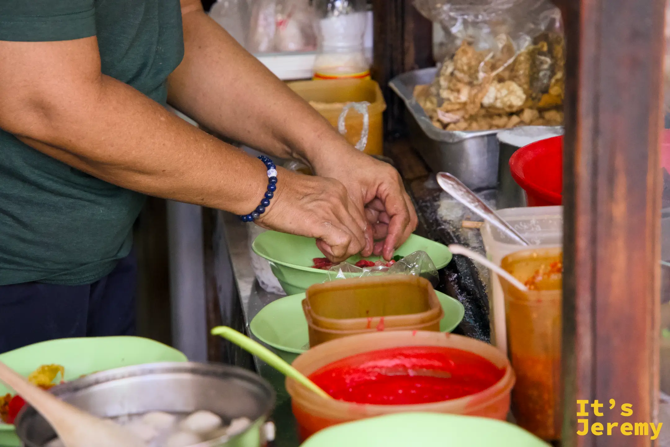 師傅手工組碗:將食材逐一擺入綠色碗中,旁邊備有各色醬汁桶與配料