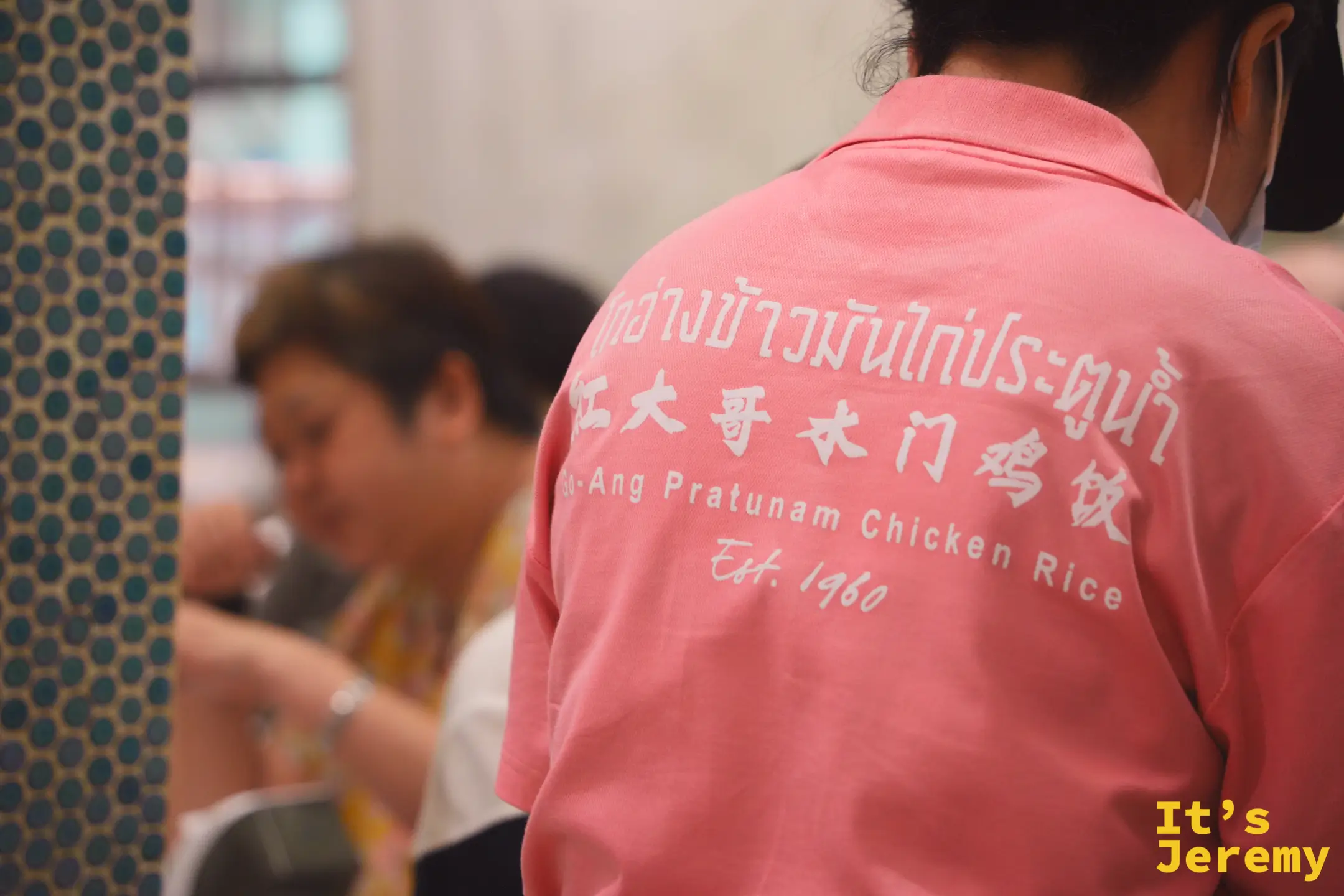 紅大哥粉紅制服員工背面：泰中英三語店名與 Est. 1960 字樣清晰可見